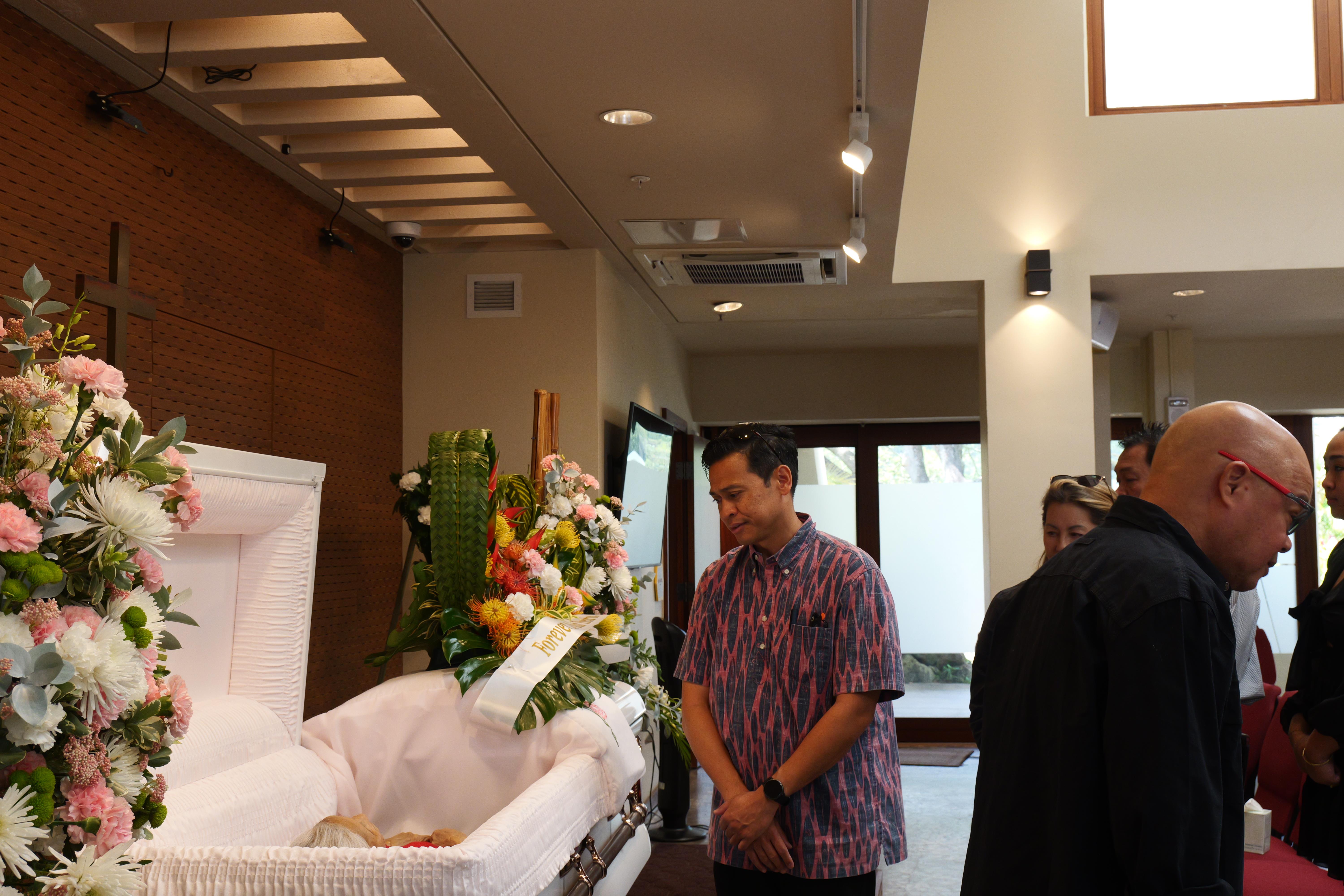 A man standing in a funeral casket
