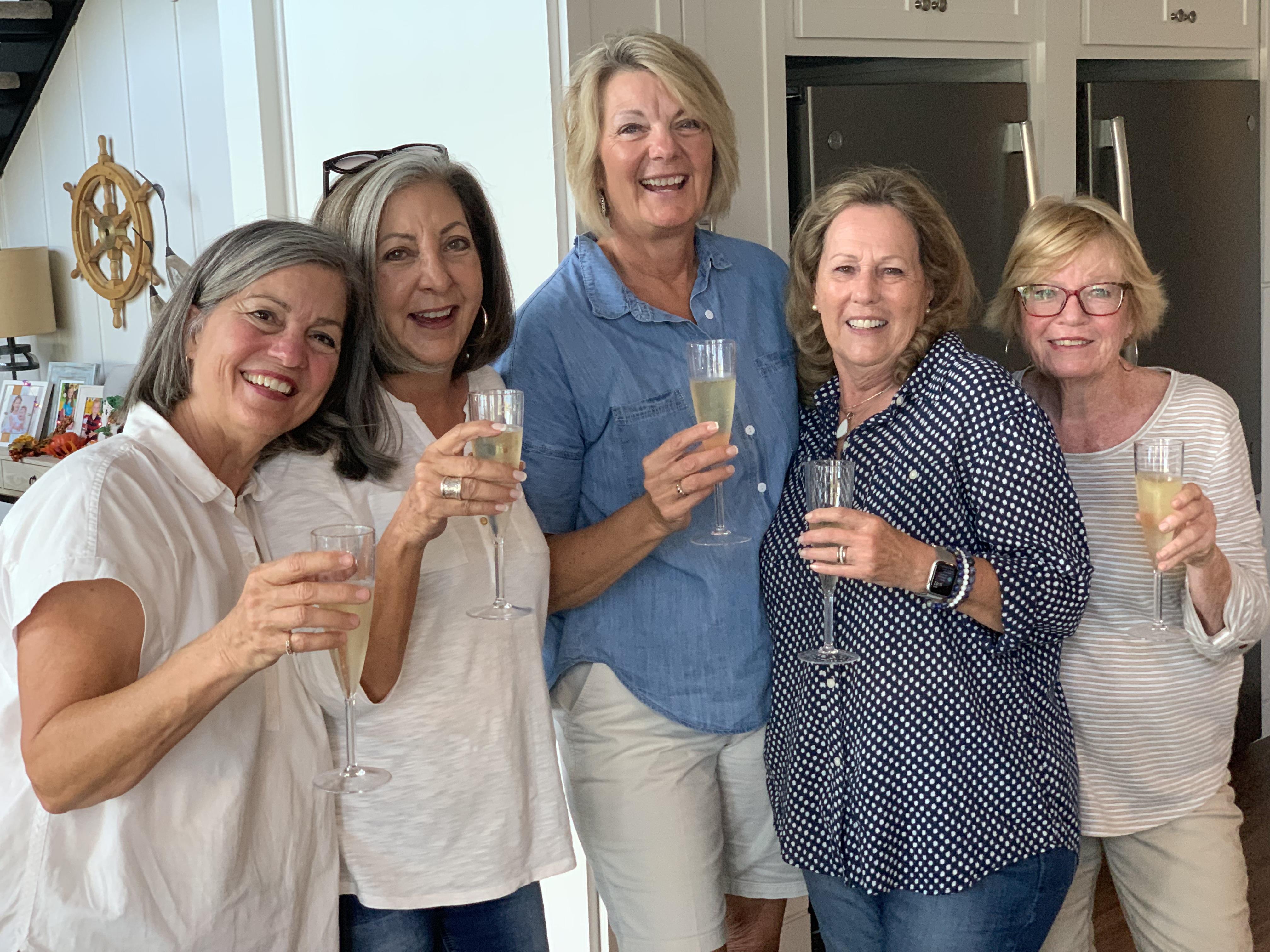 A group of women holding glasses of champagne