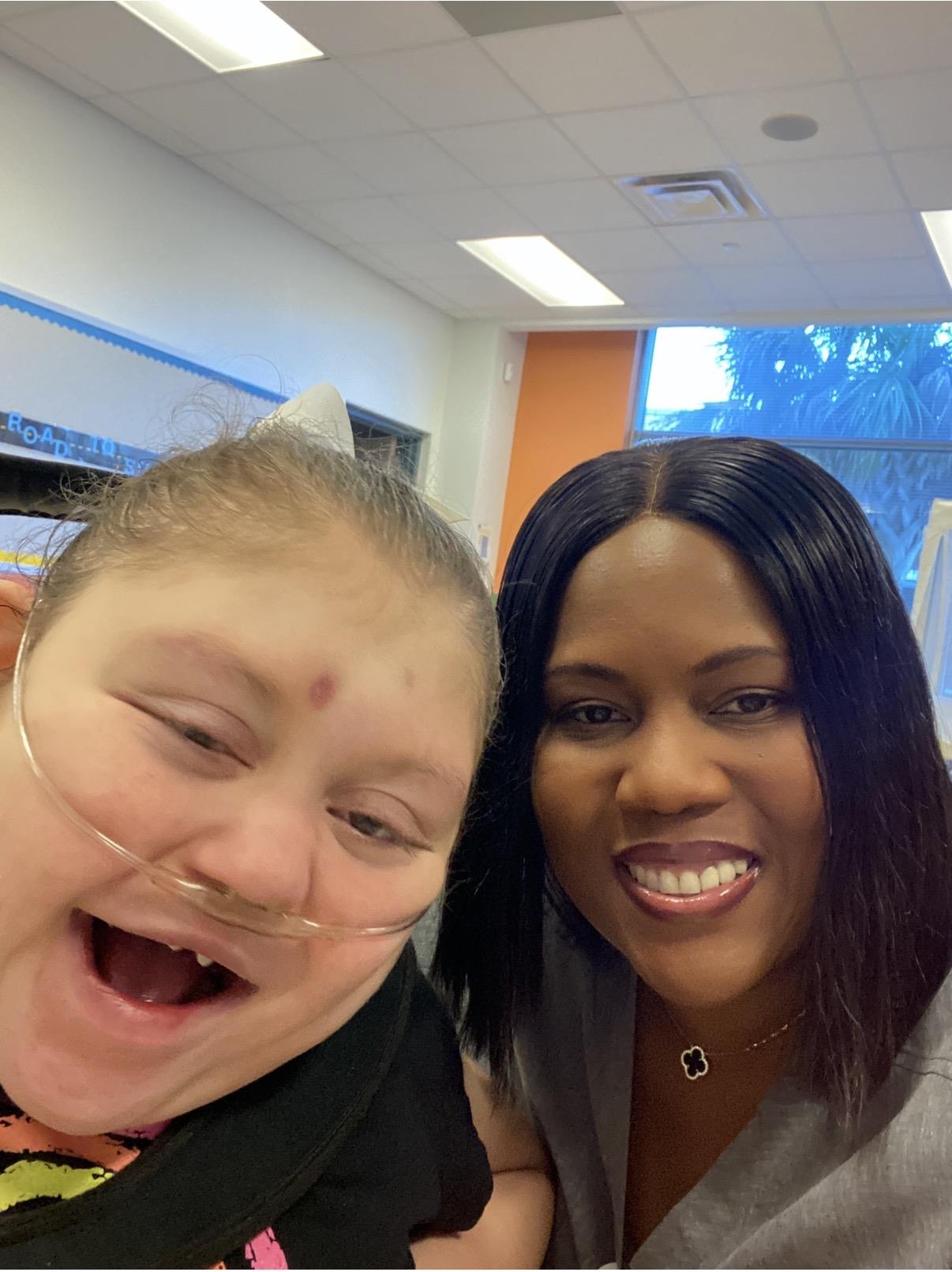 A woman smiling next to a smiling girl