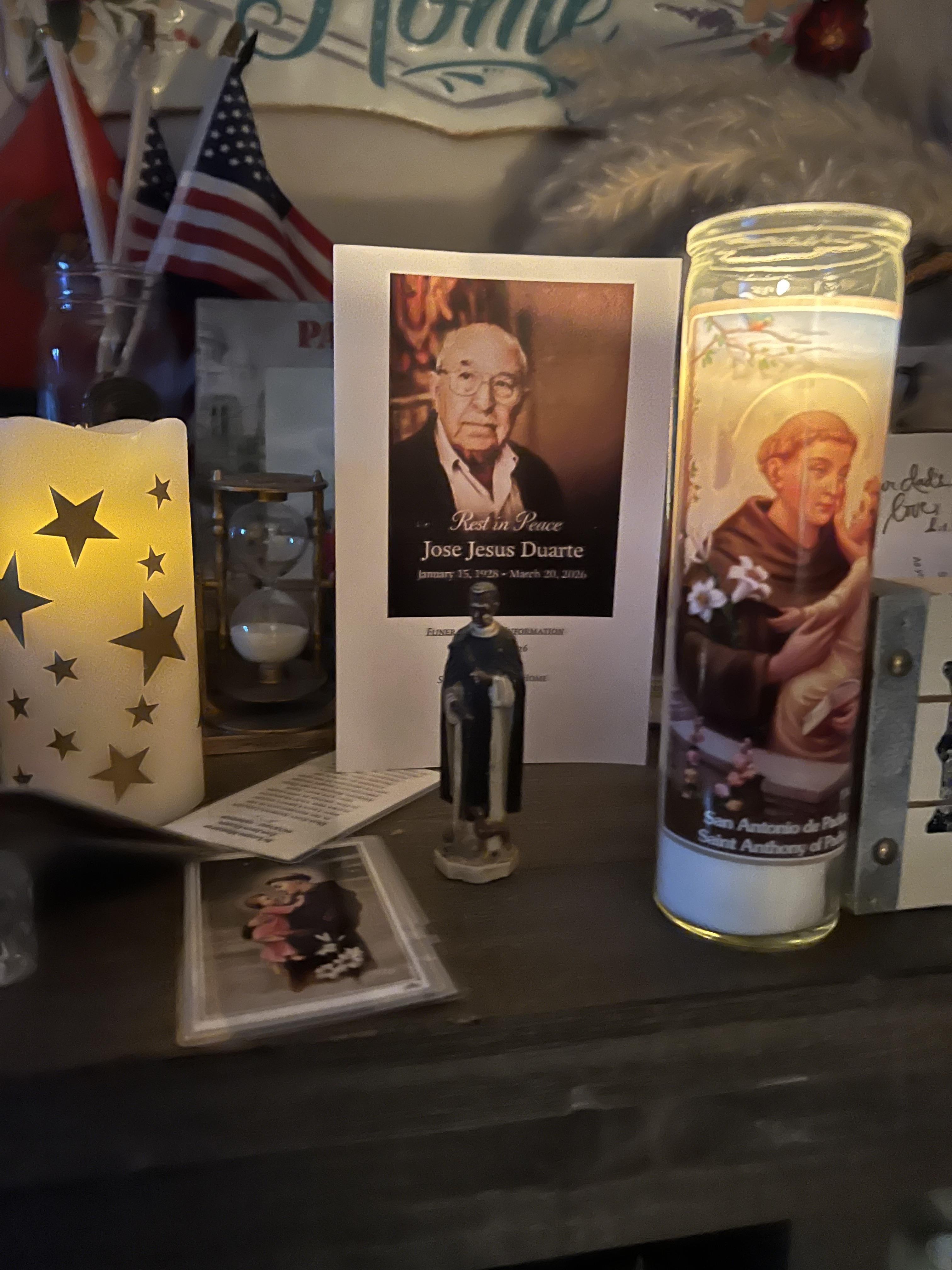 A candle and a statue on a table