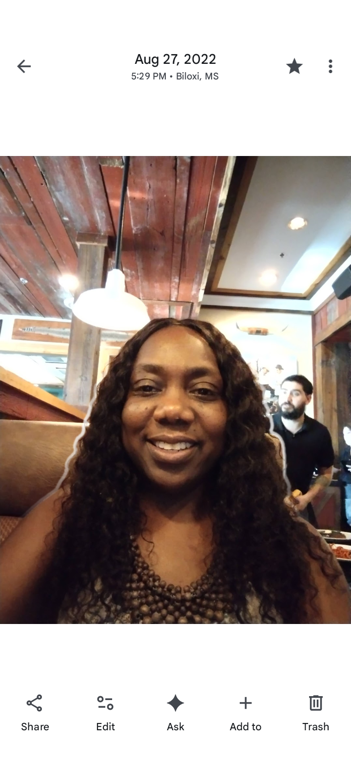 A woman with long curly hair sitting in a booth