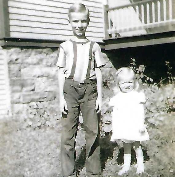 A boy and girl standing in front of a house
