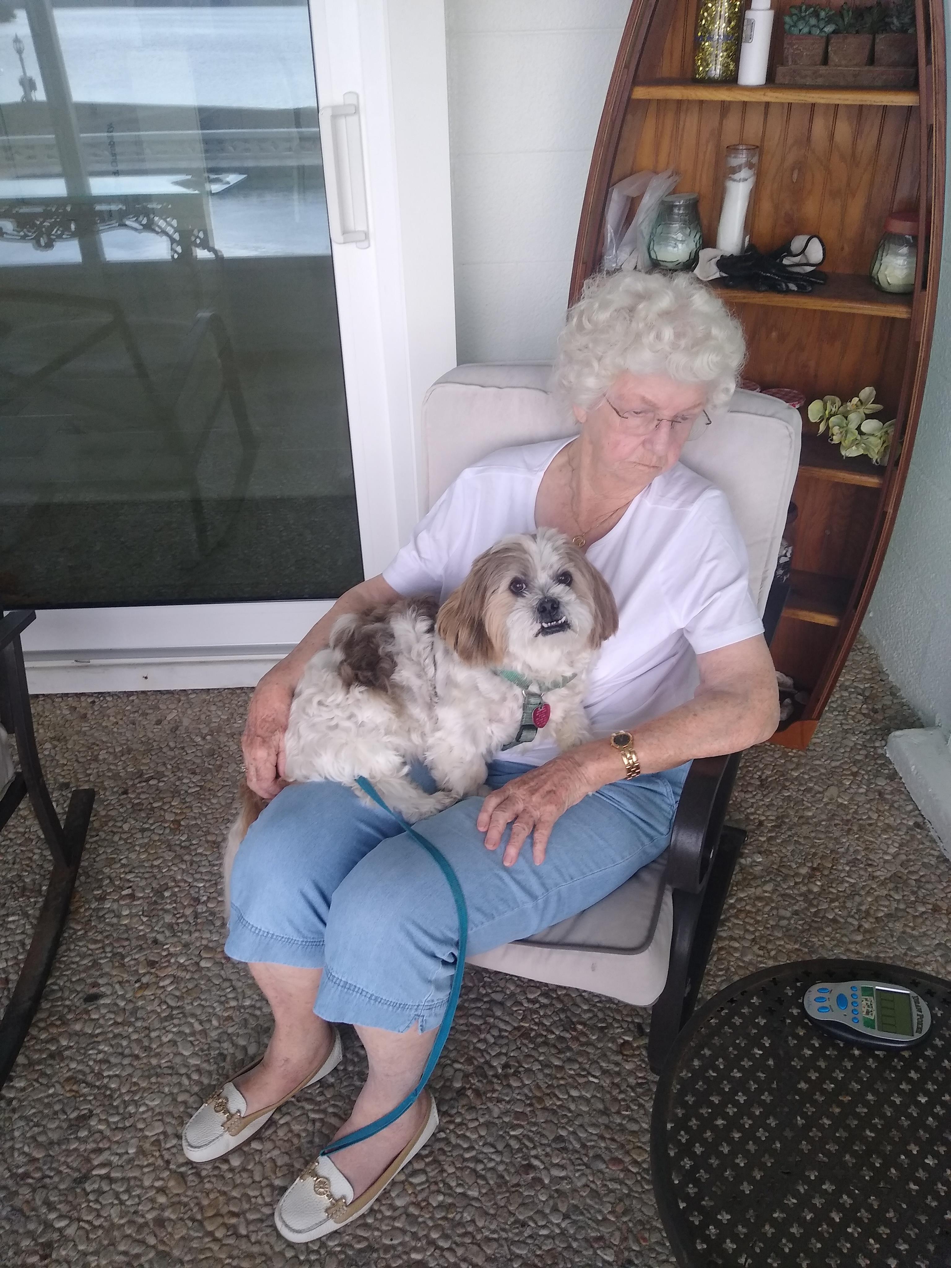 A woman sitting in a chair holding a dog