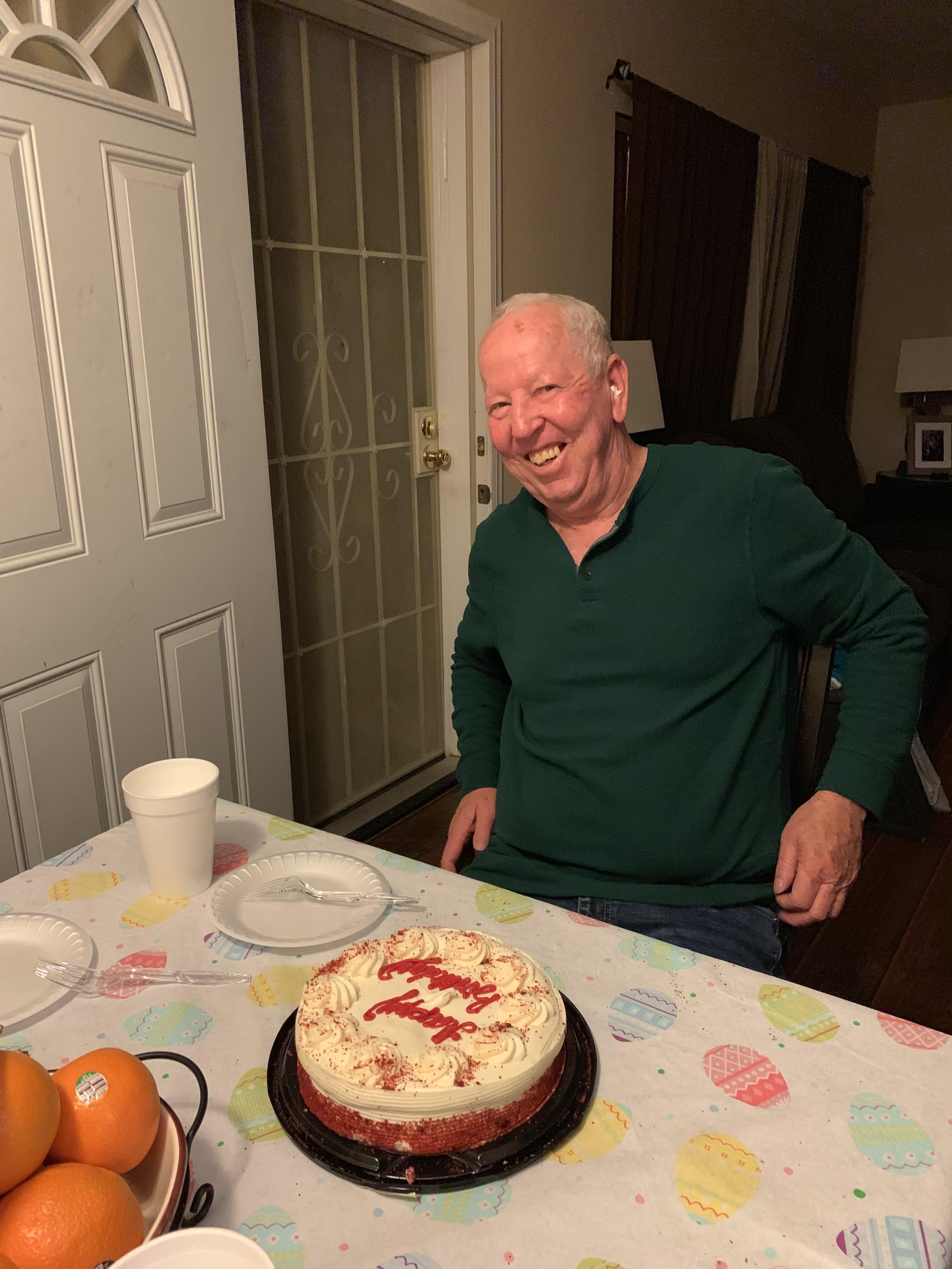 A man sitting at a table with a cake