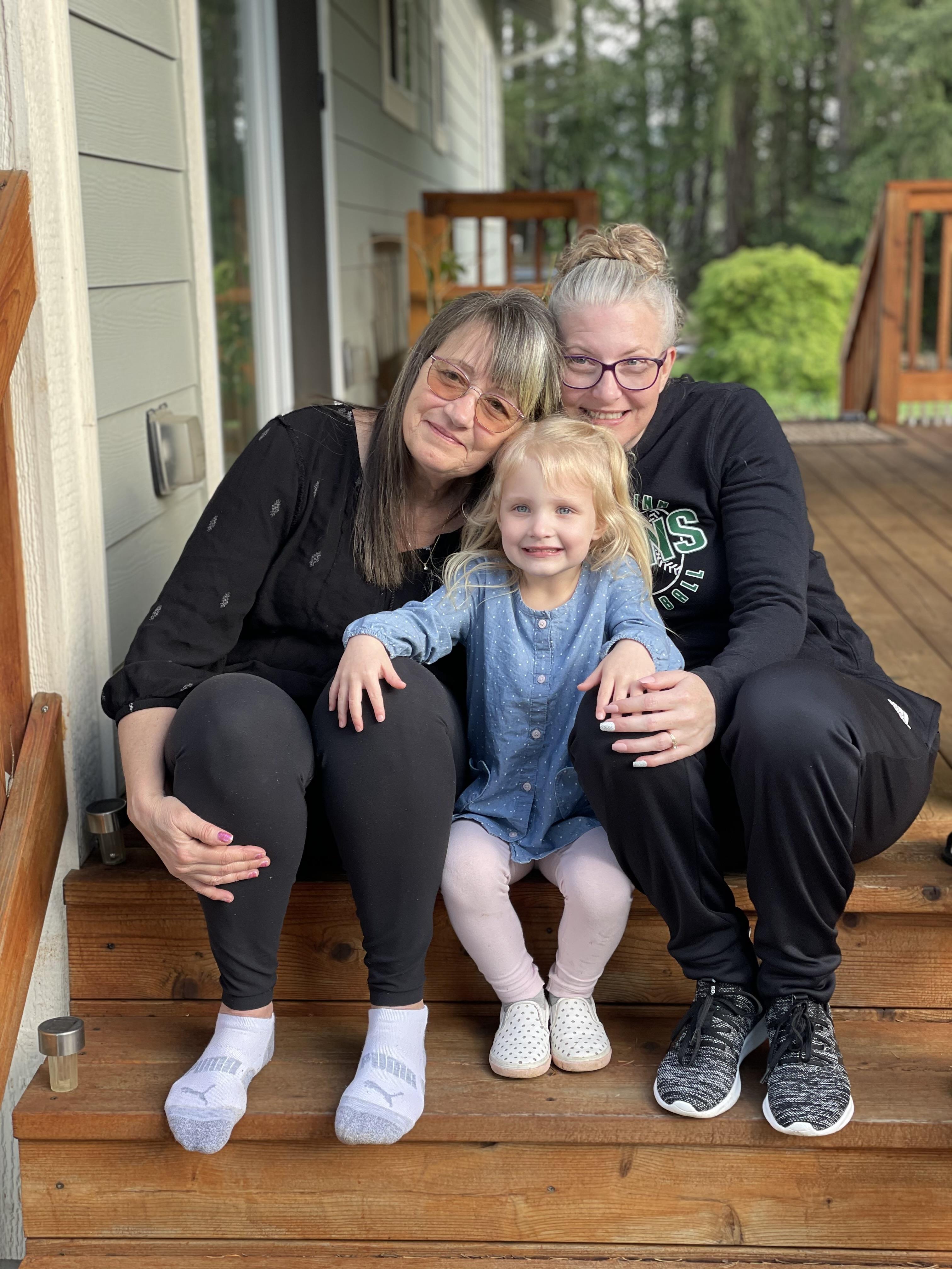 A group of women and a girl sitting on a porch