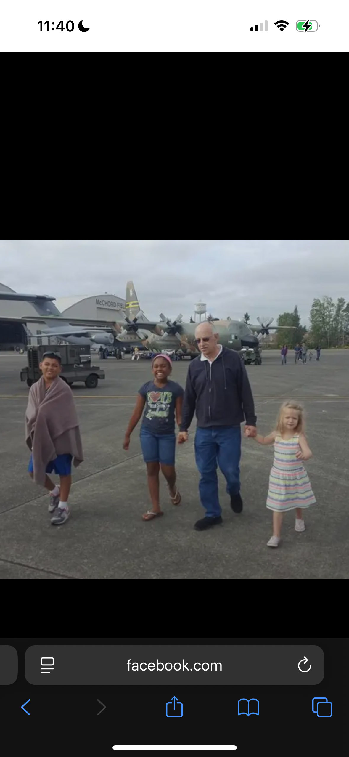 A group of people walking in front of an airplane