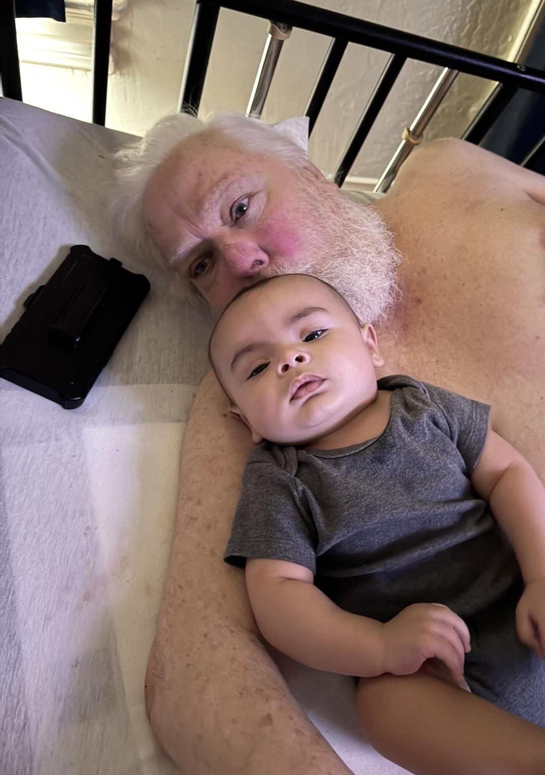 A man lying on a bed with a baby