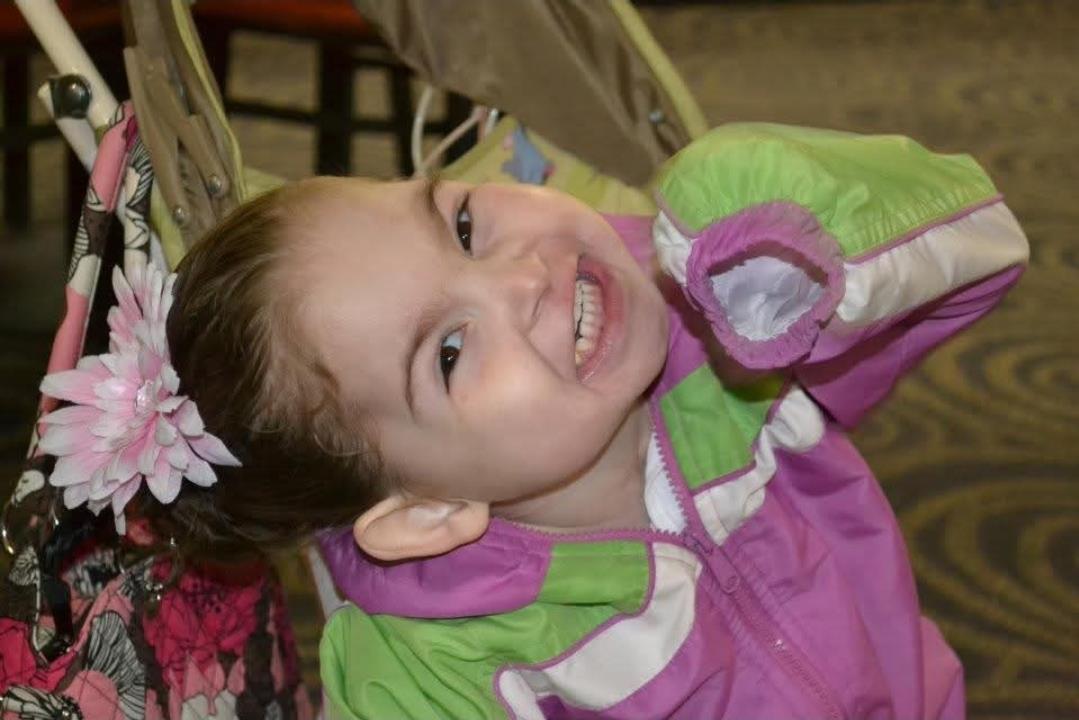 A girl smiling with her hair in a ponytail