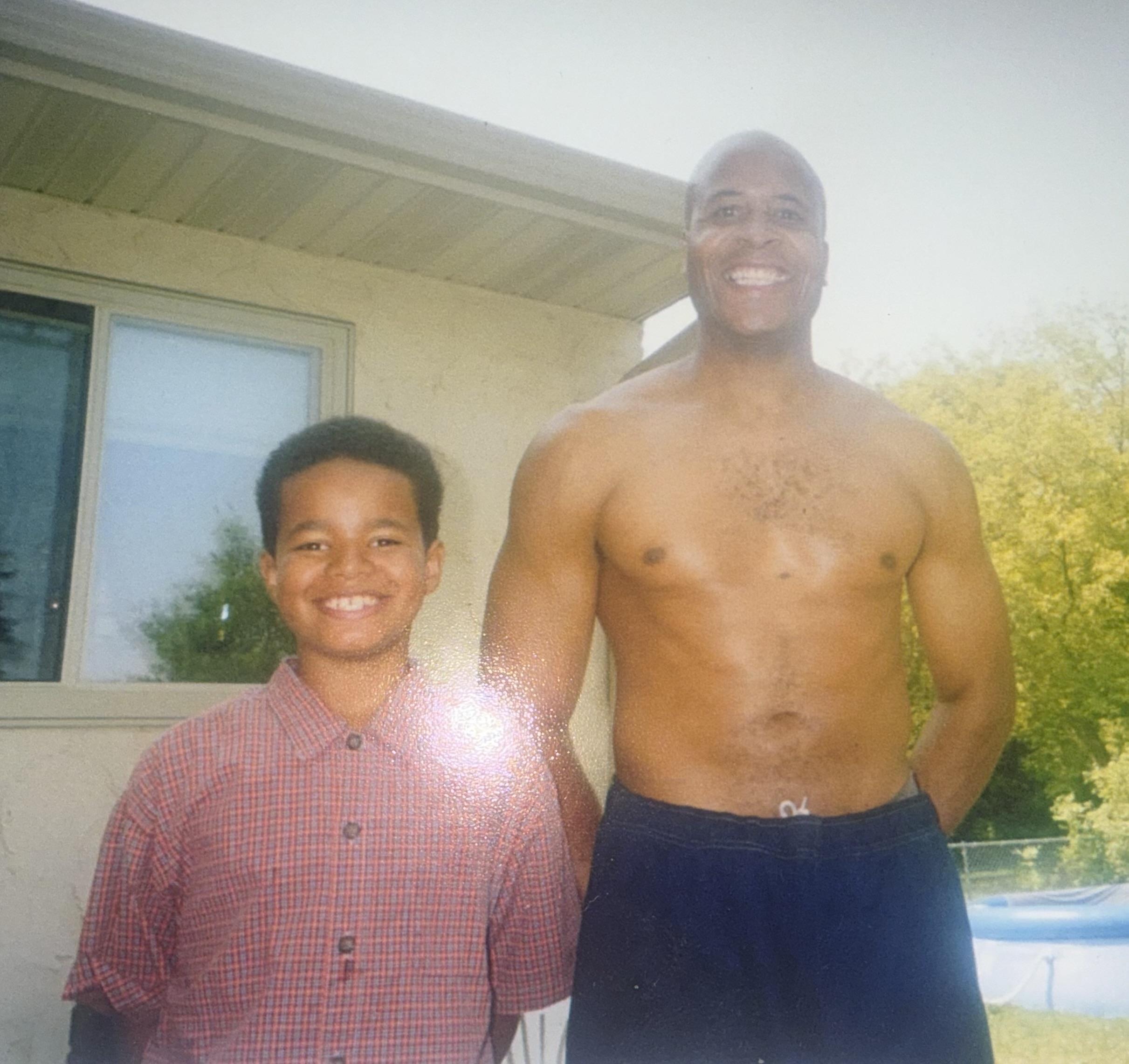 A man and boy standing in front of a house