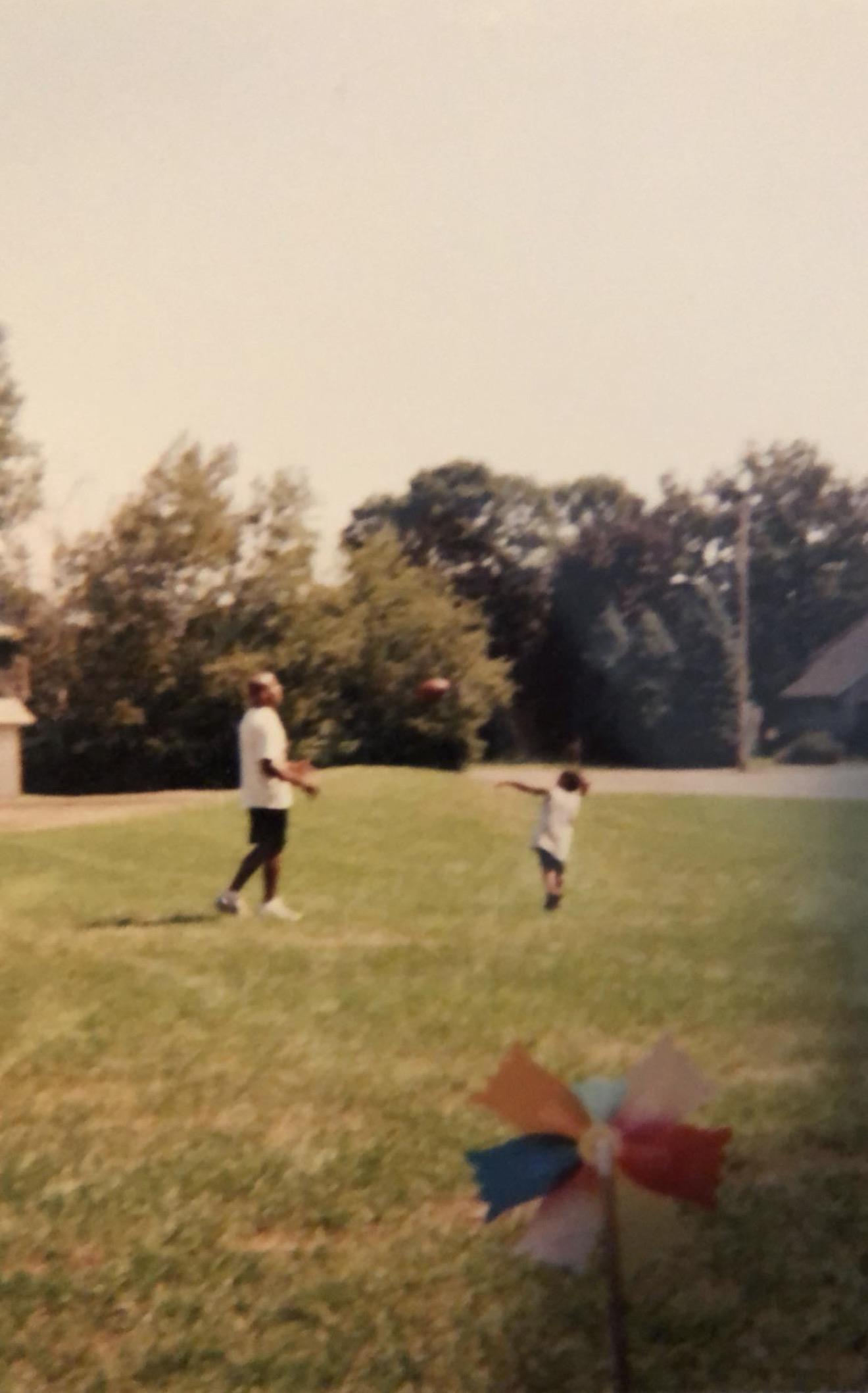 A man and child playing with a ball