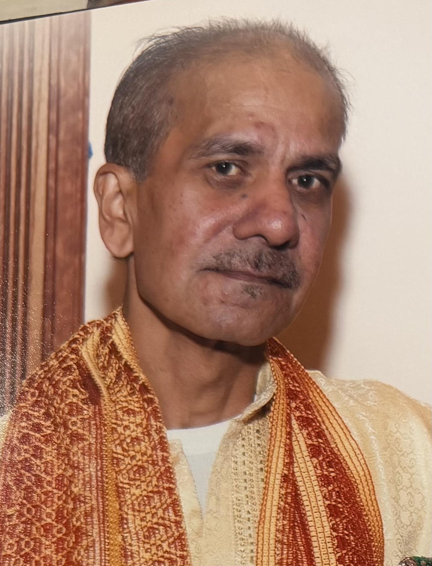 A man with a mustache wearing a scarf