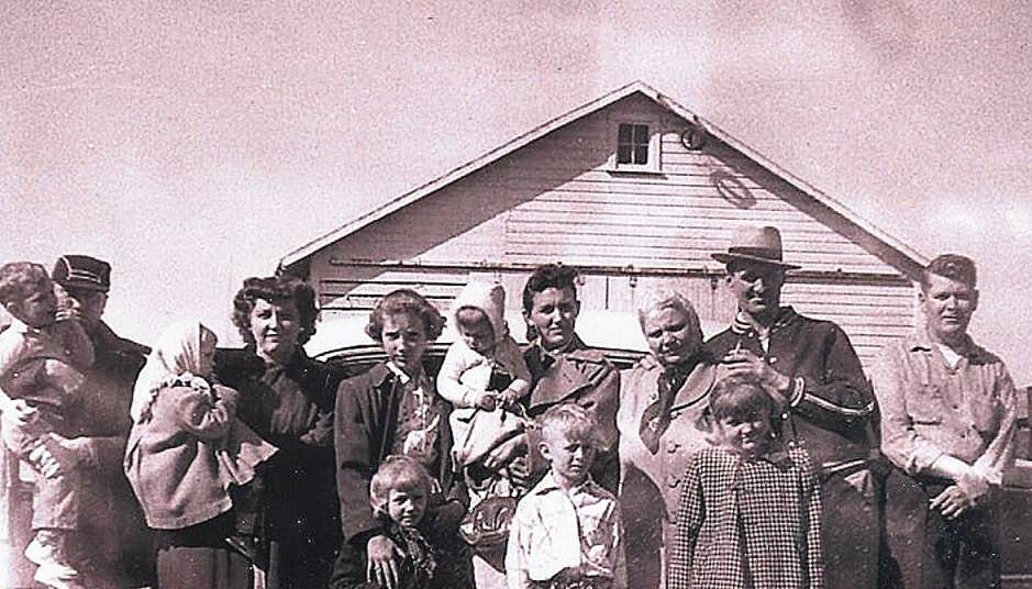 A group of people standing in front of a house