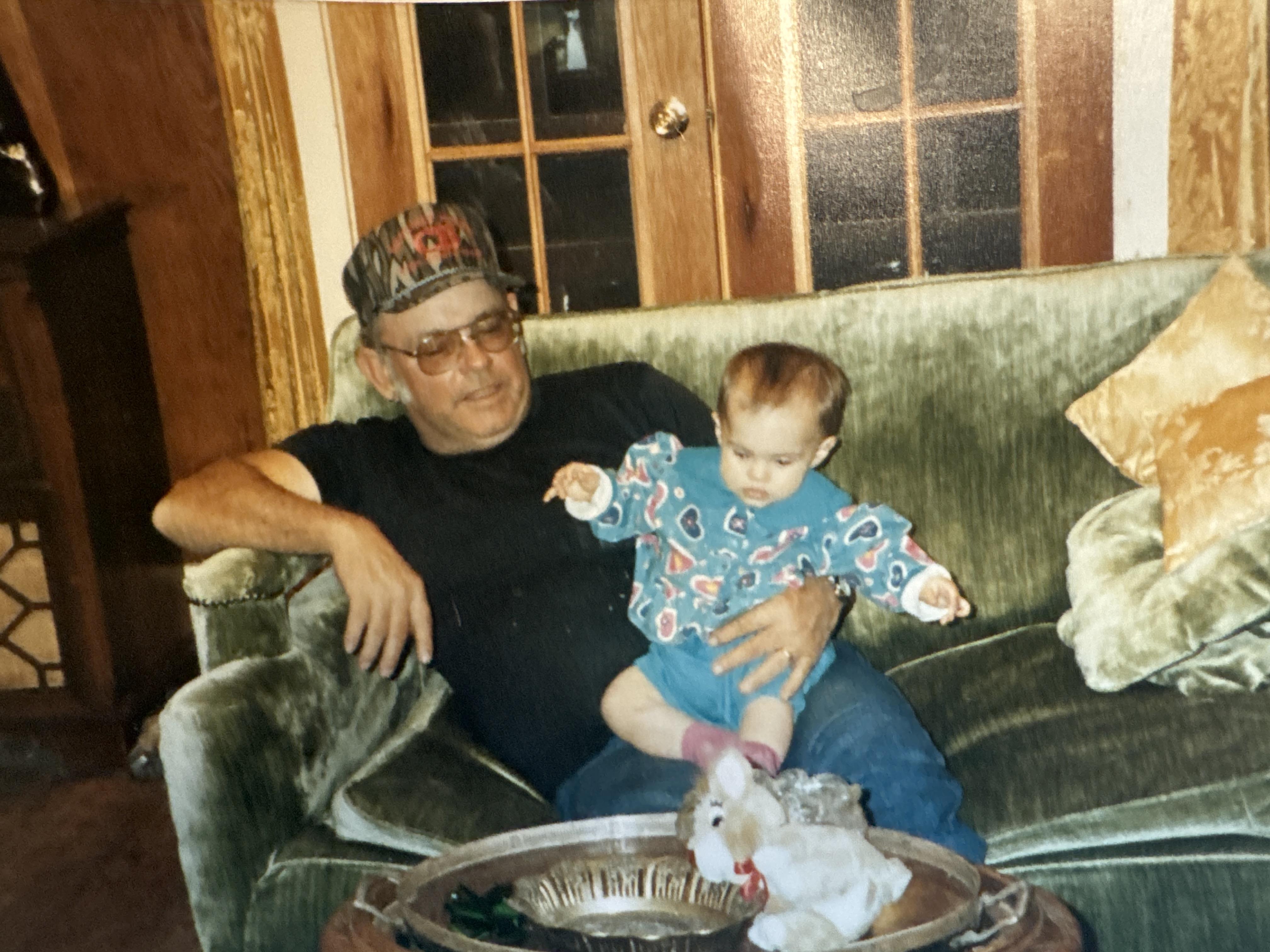 A man sitting on a couch holding a baby