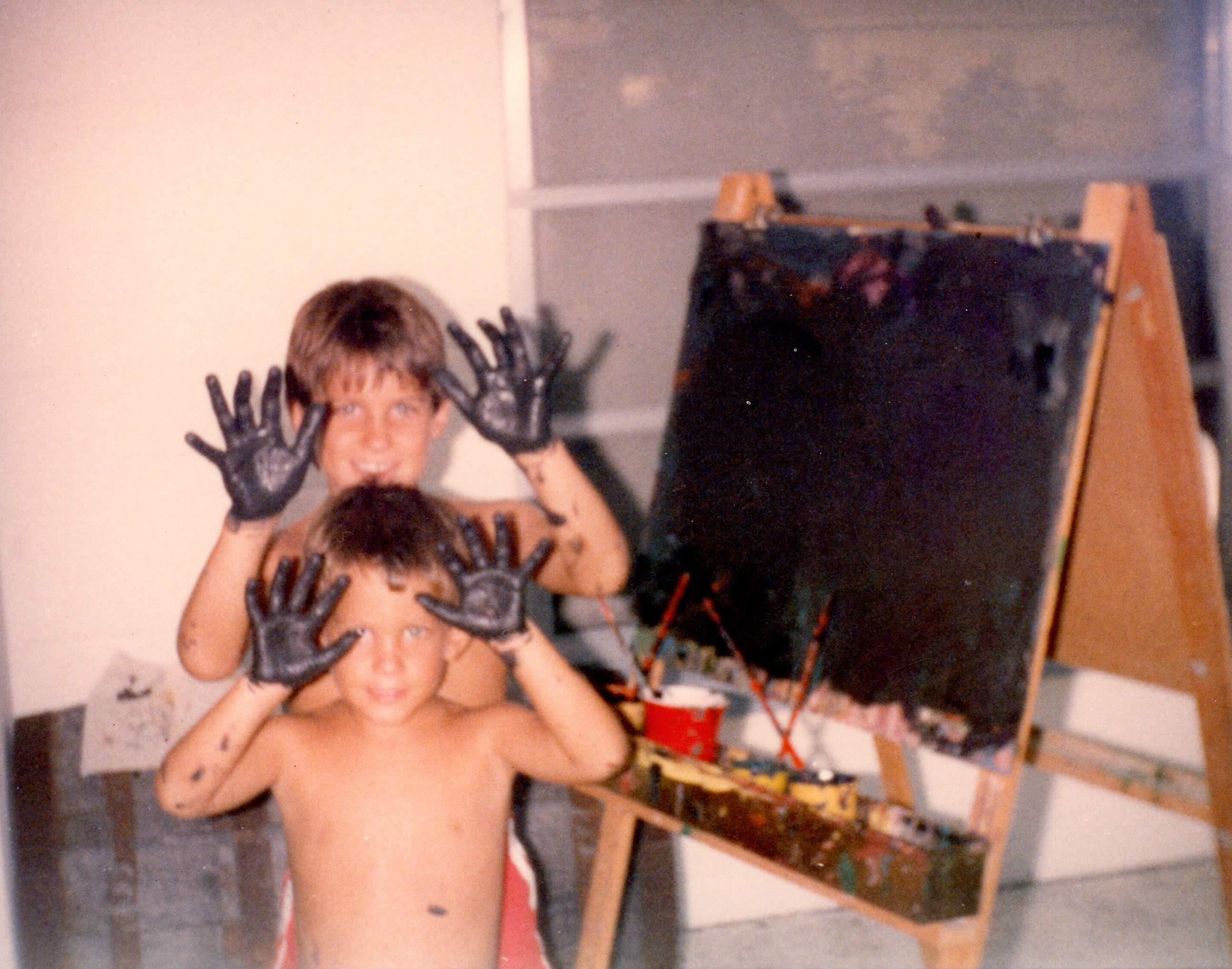 A pair of young boys with black paint on their hands