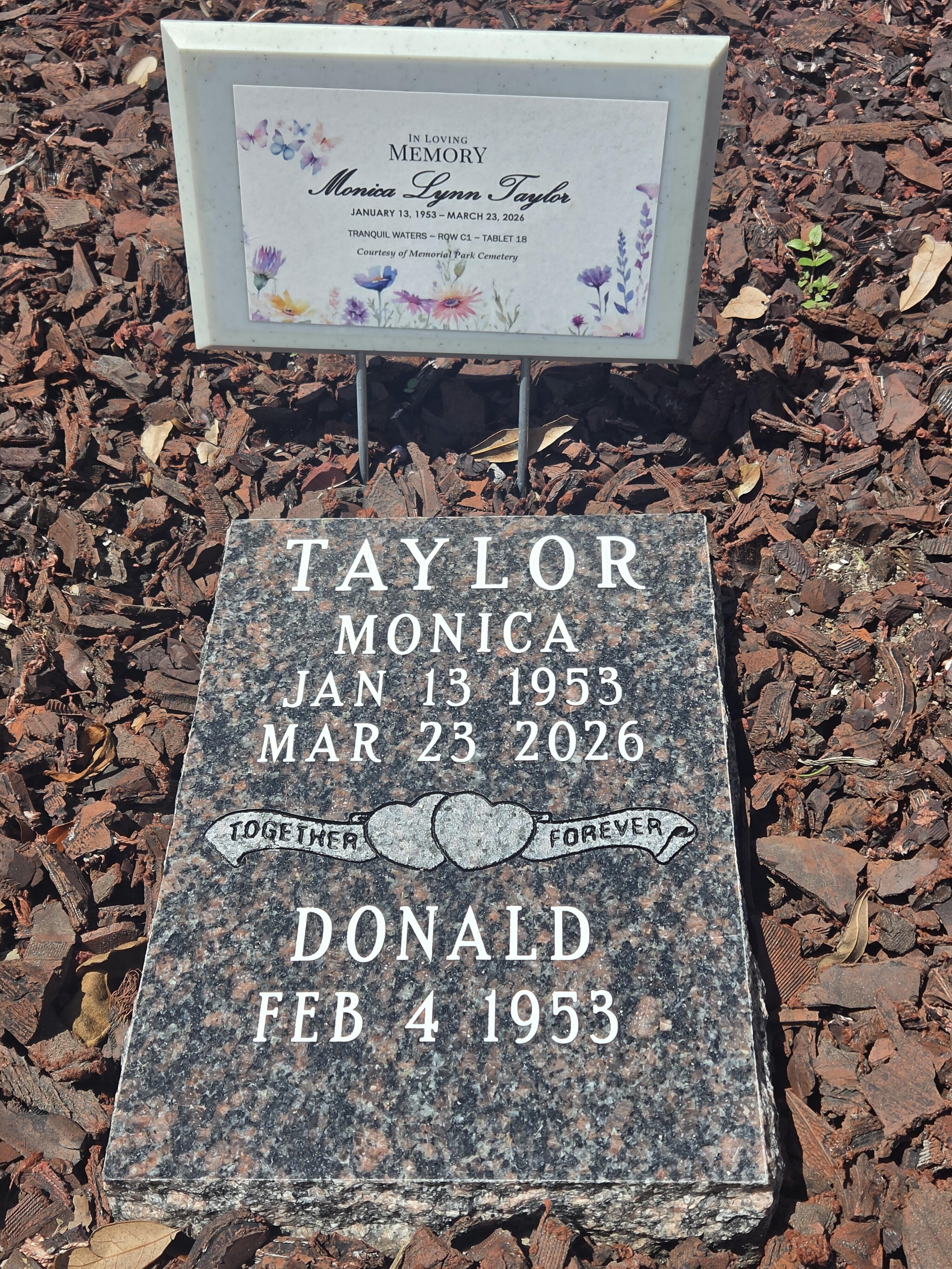 A grave stone with a sign on it