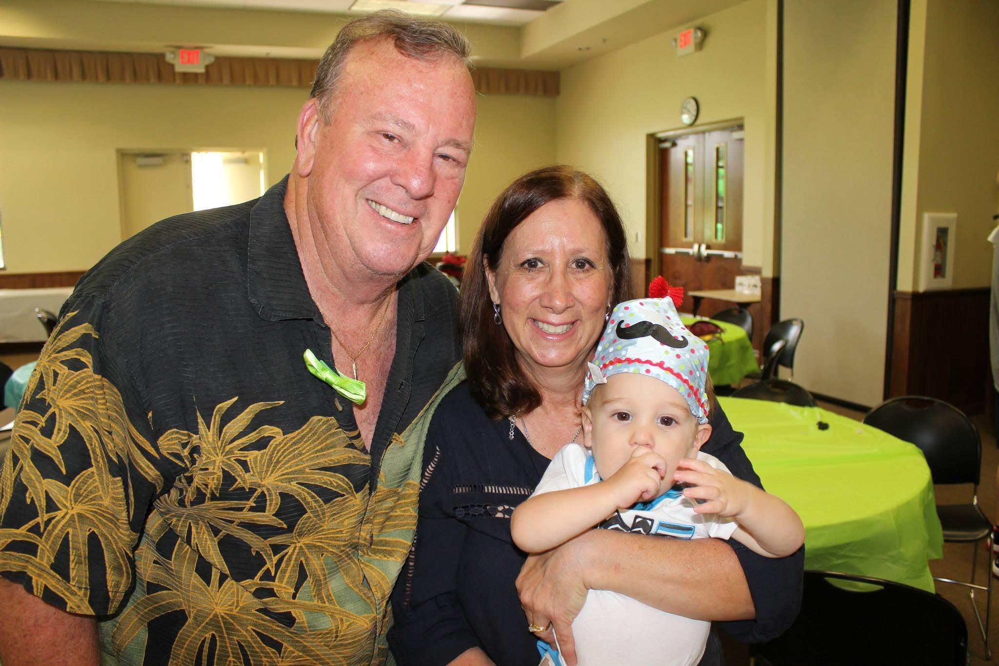 A man and woman holding a baby