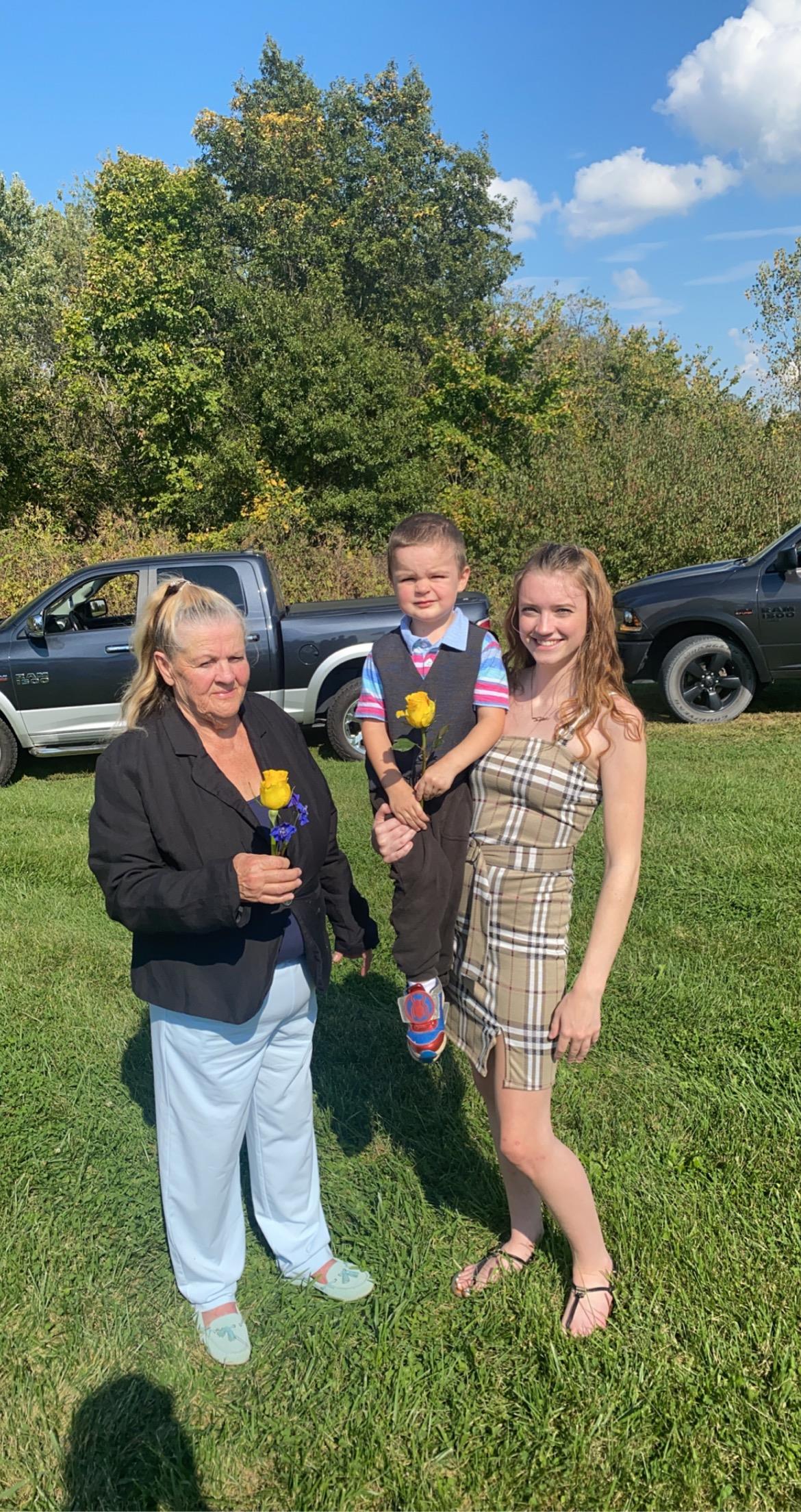 A group of people standing in a grassy area