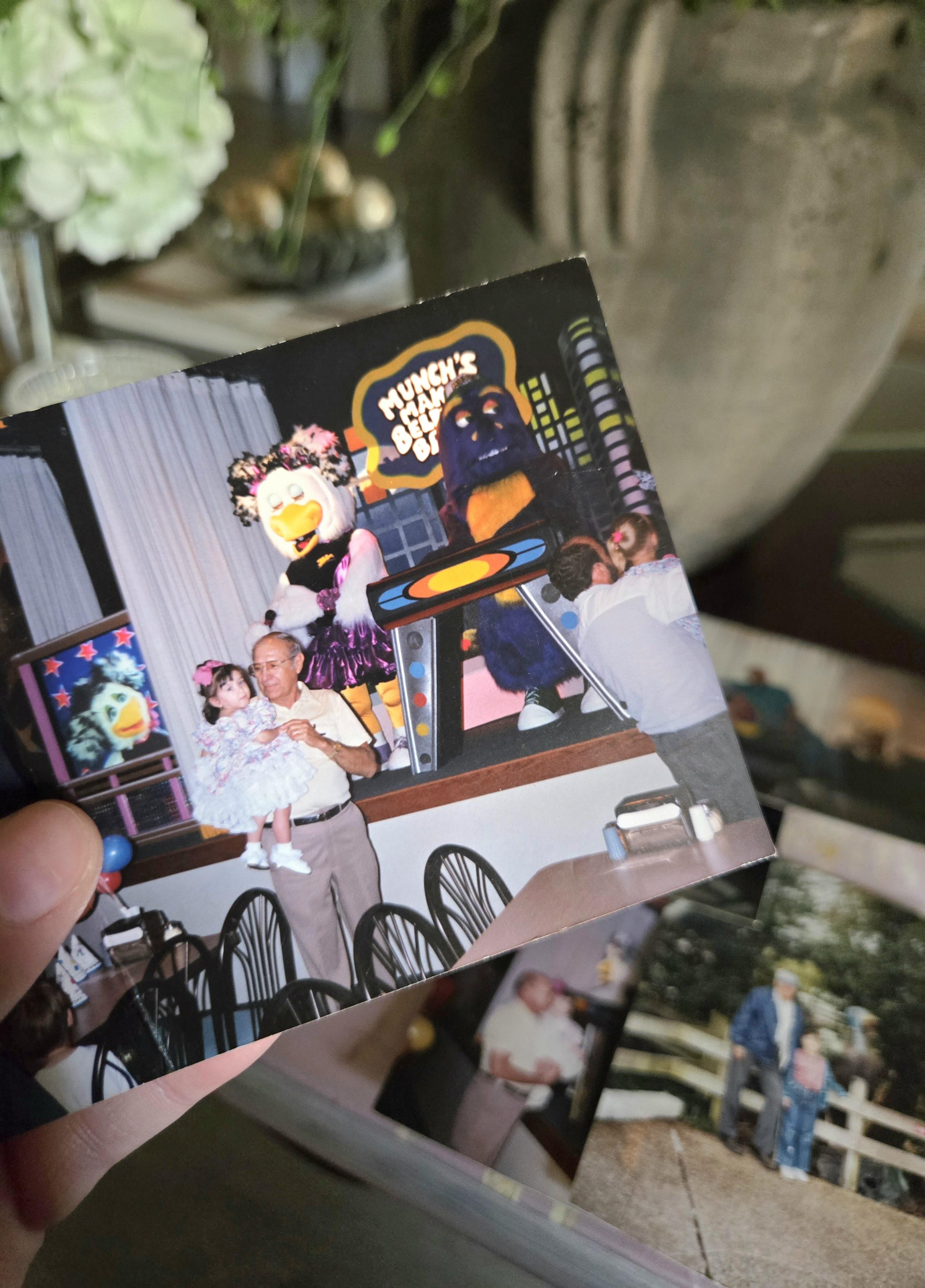 A person holding a photo of a man and a child