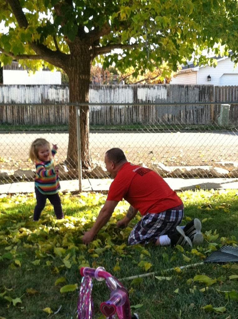 A man and child playing in the grass