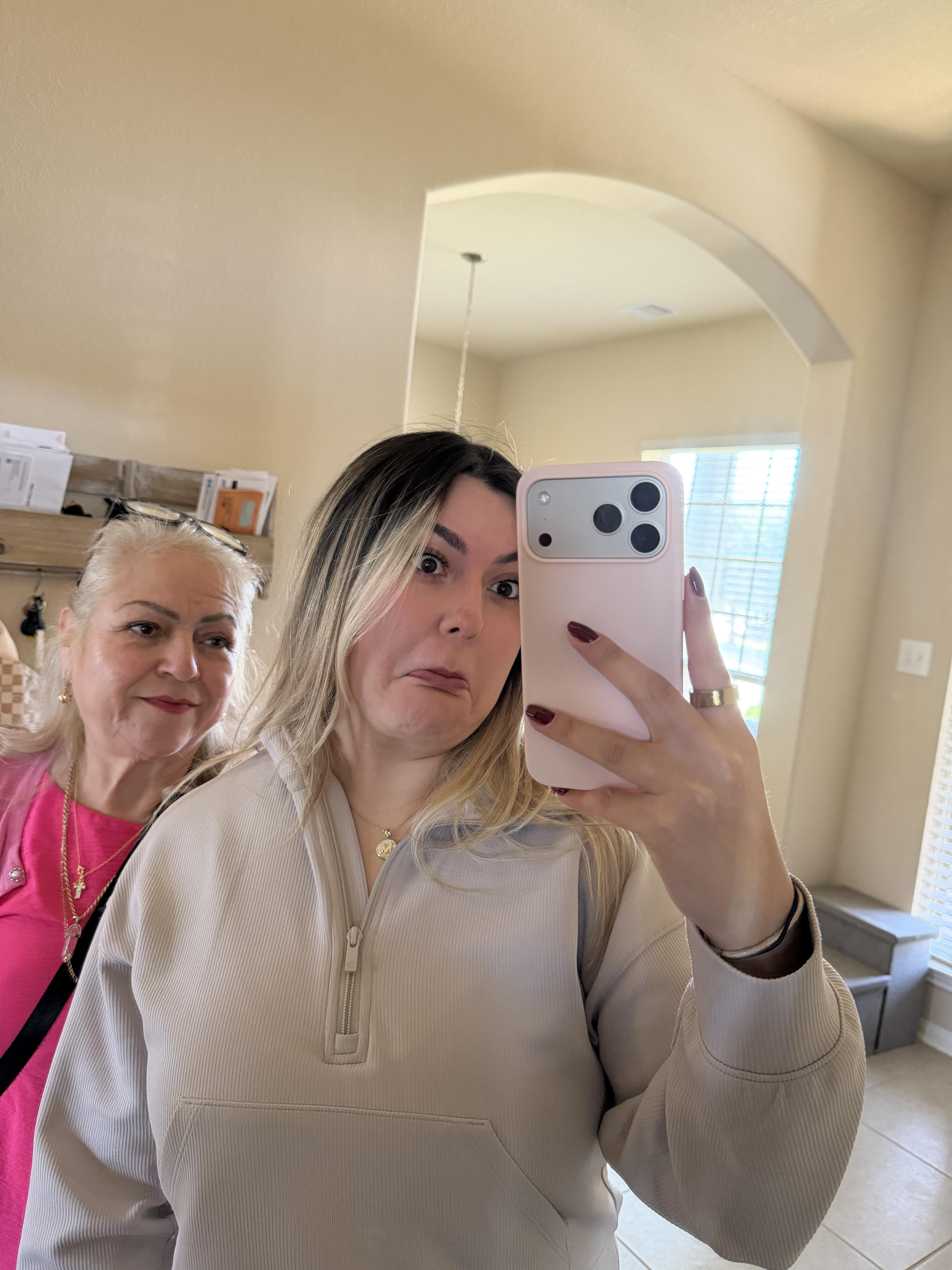 A woman taking a selfie with another woman