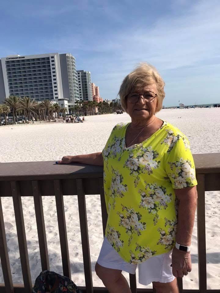 A woman leaning on a railing on a beach