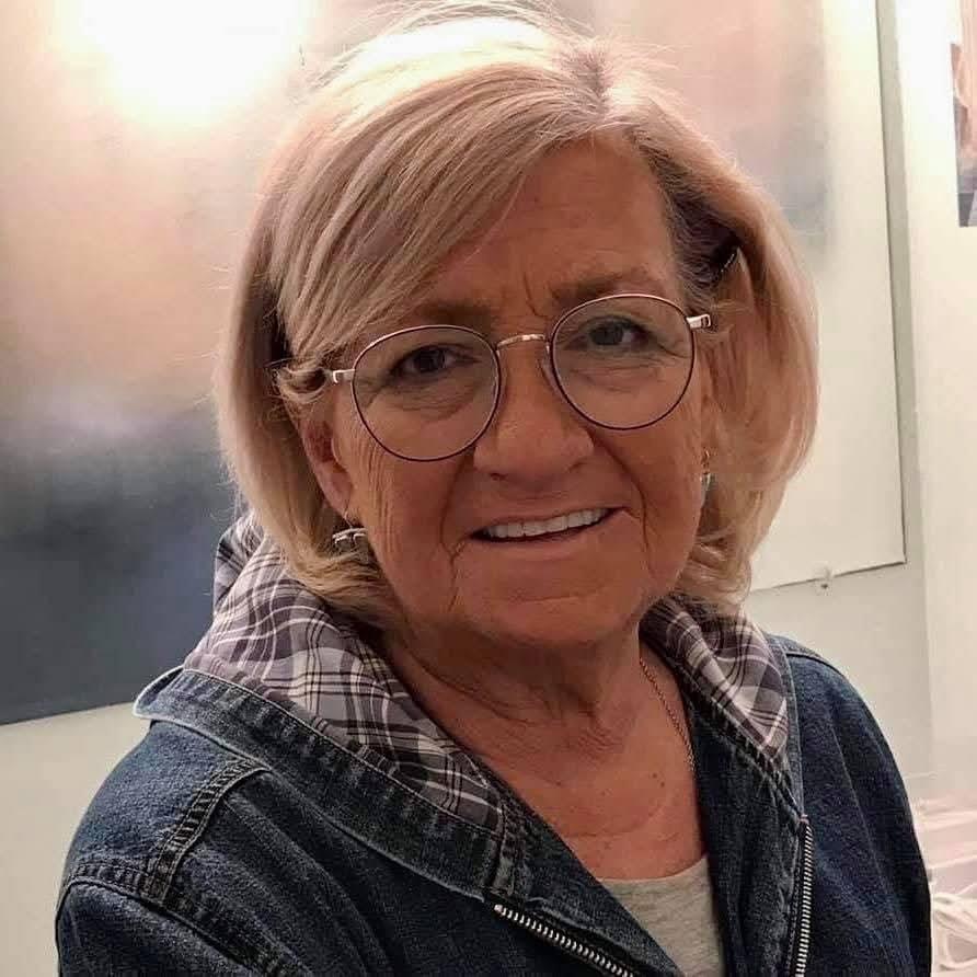 A woman wearing glasses and a denim jacket