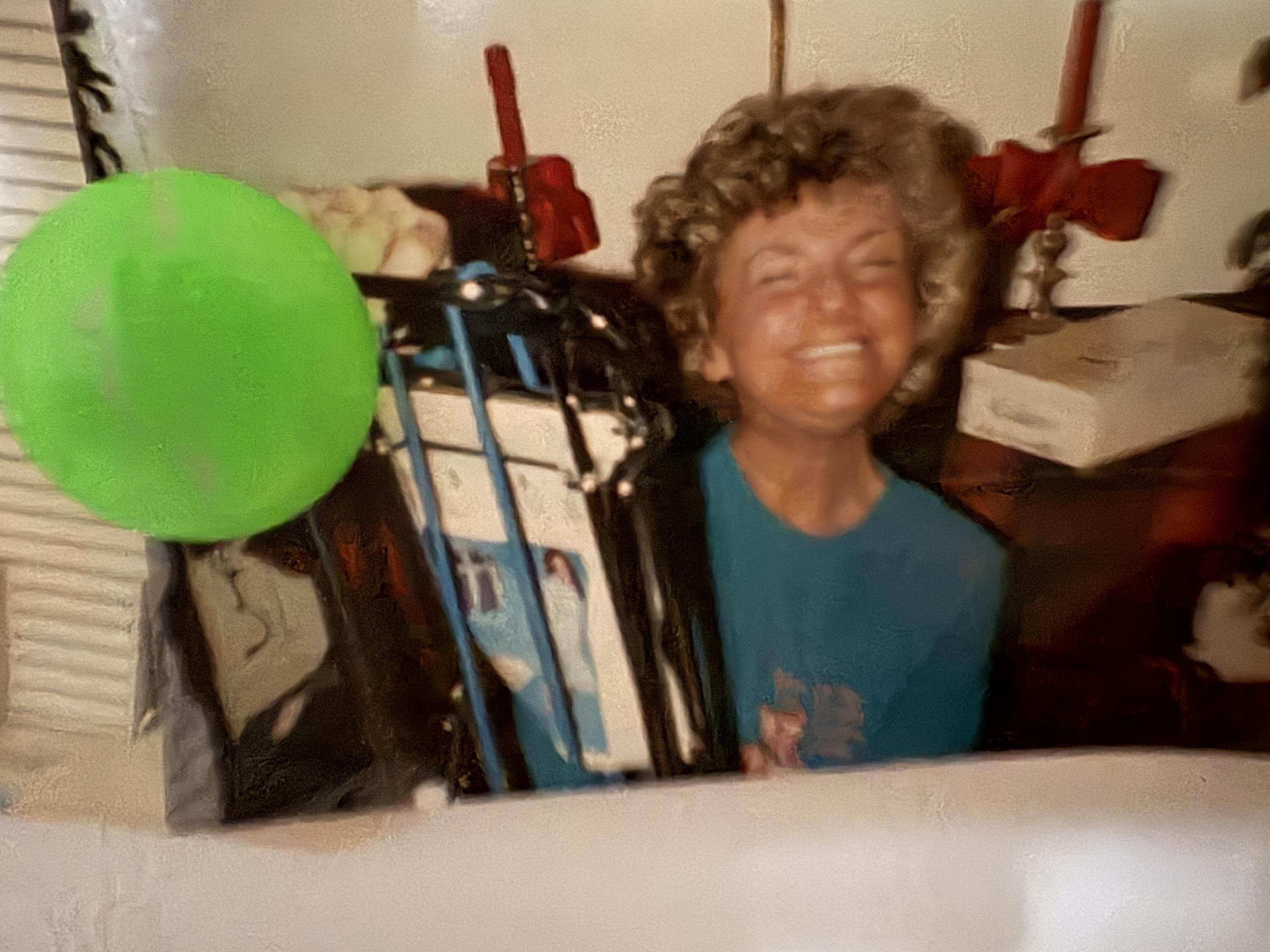 A woman smiling with a green balloon