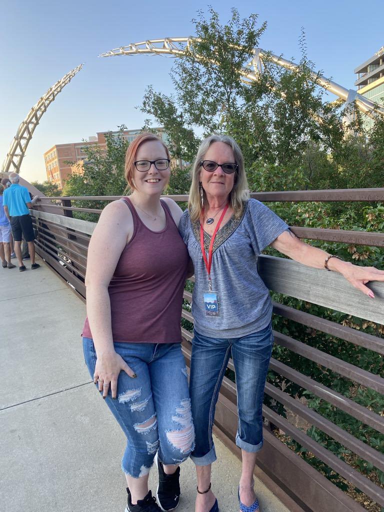 Two women standing on a bridge