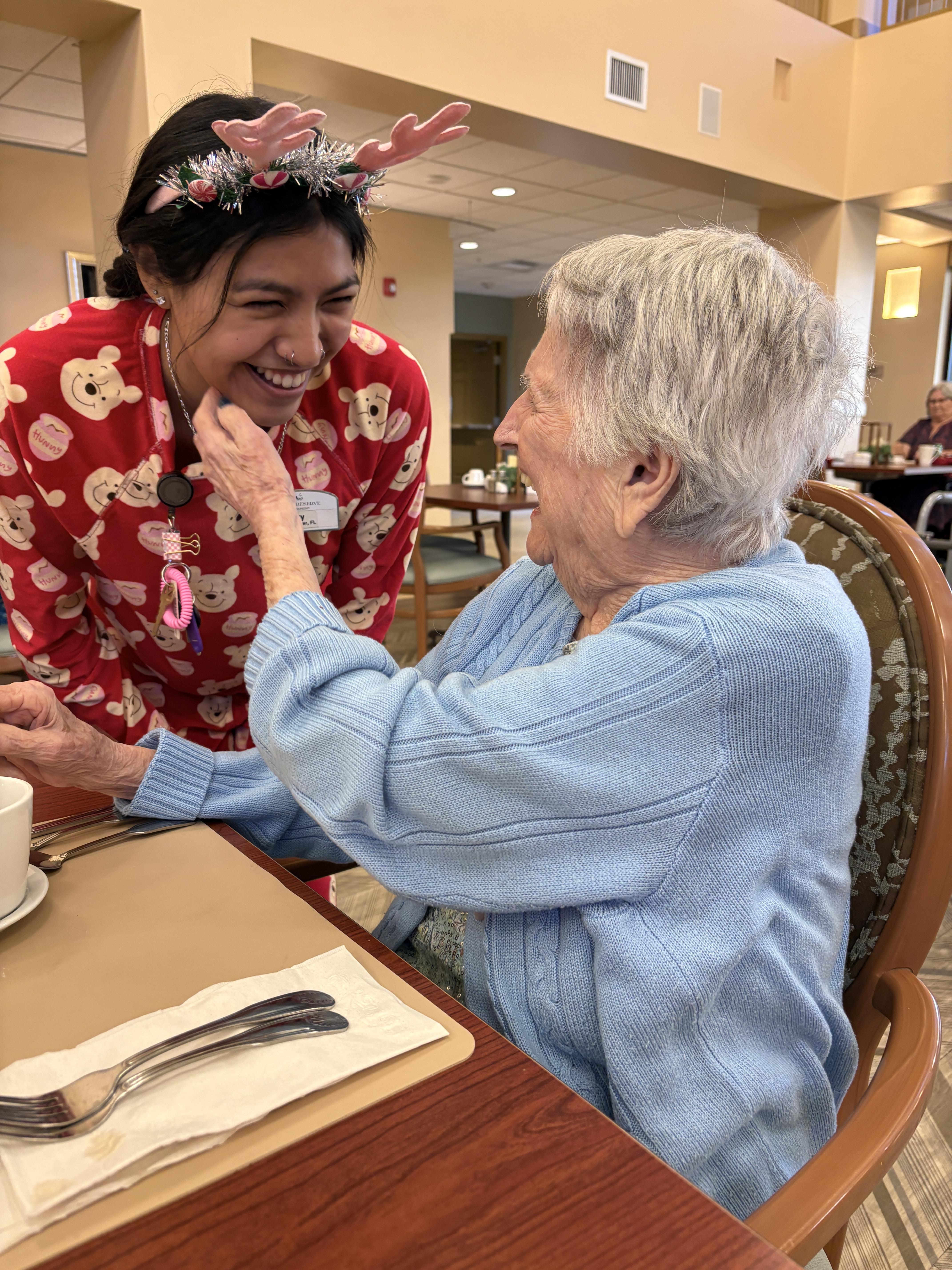 A woman smiling at an old woman