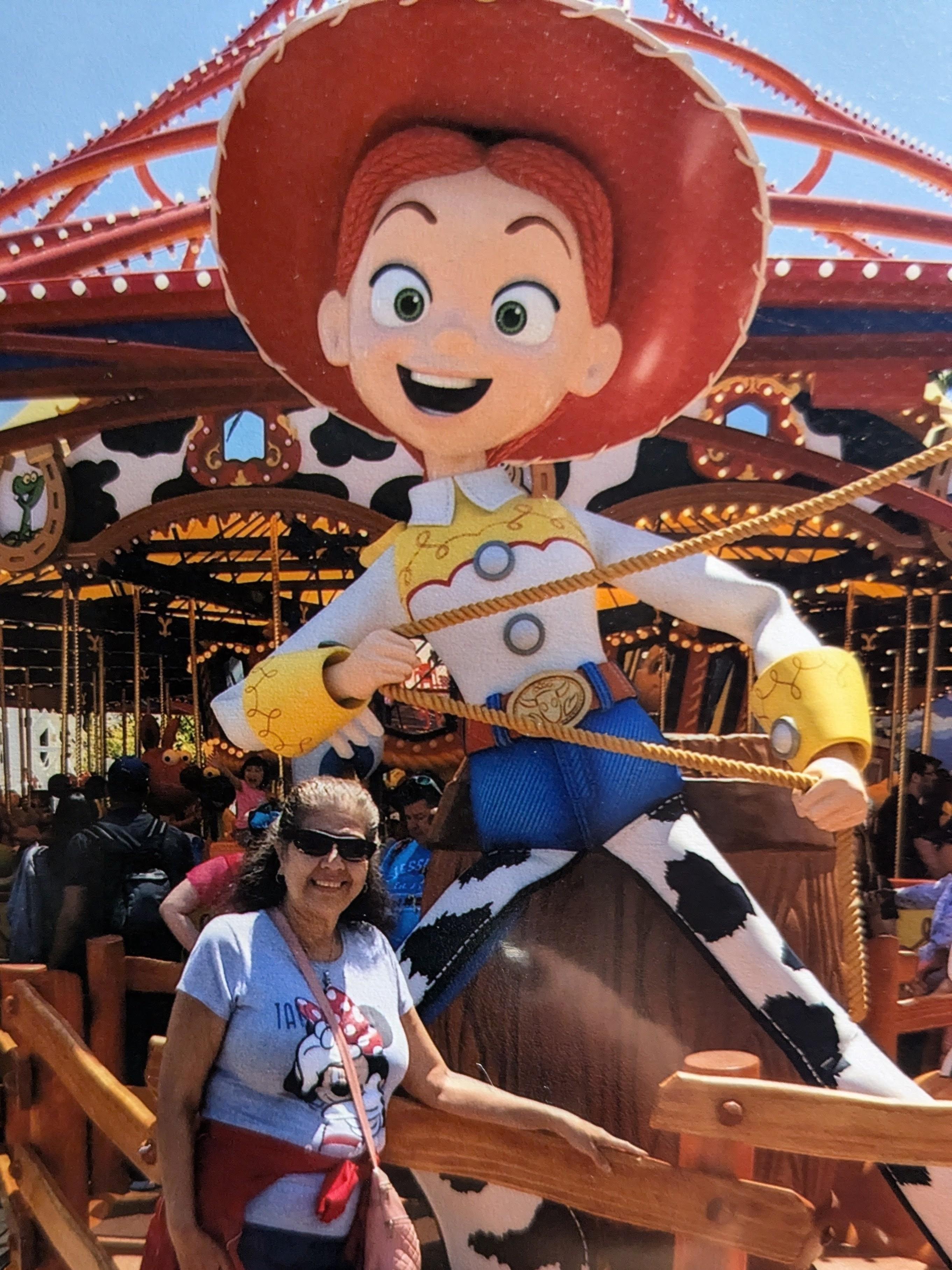 A woman standing next to a large cartoon character on a carousel