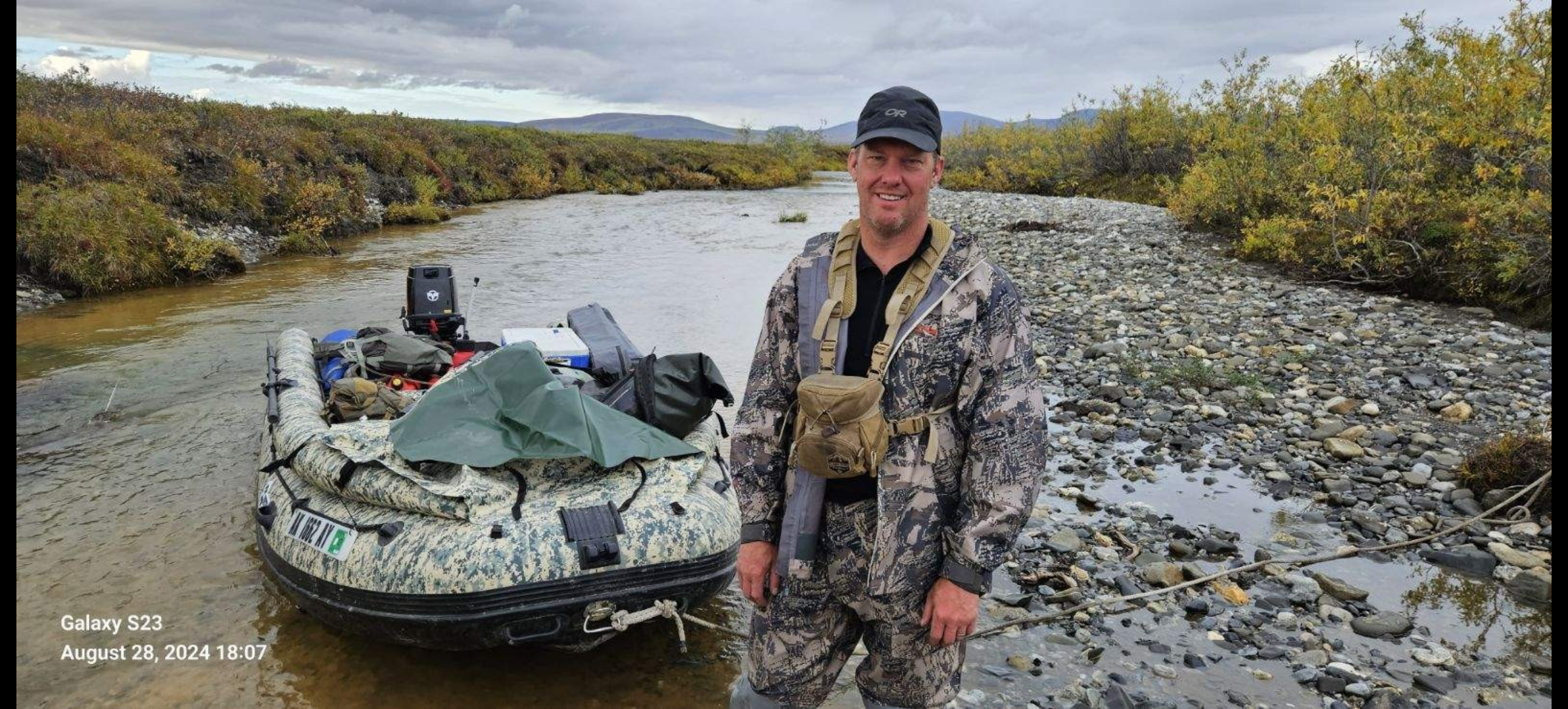 A man standing in a river with a boat