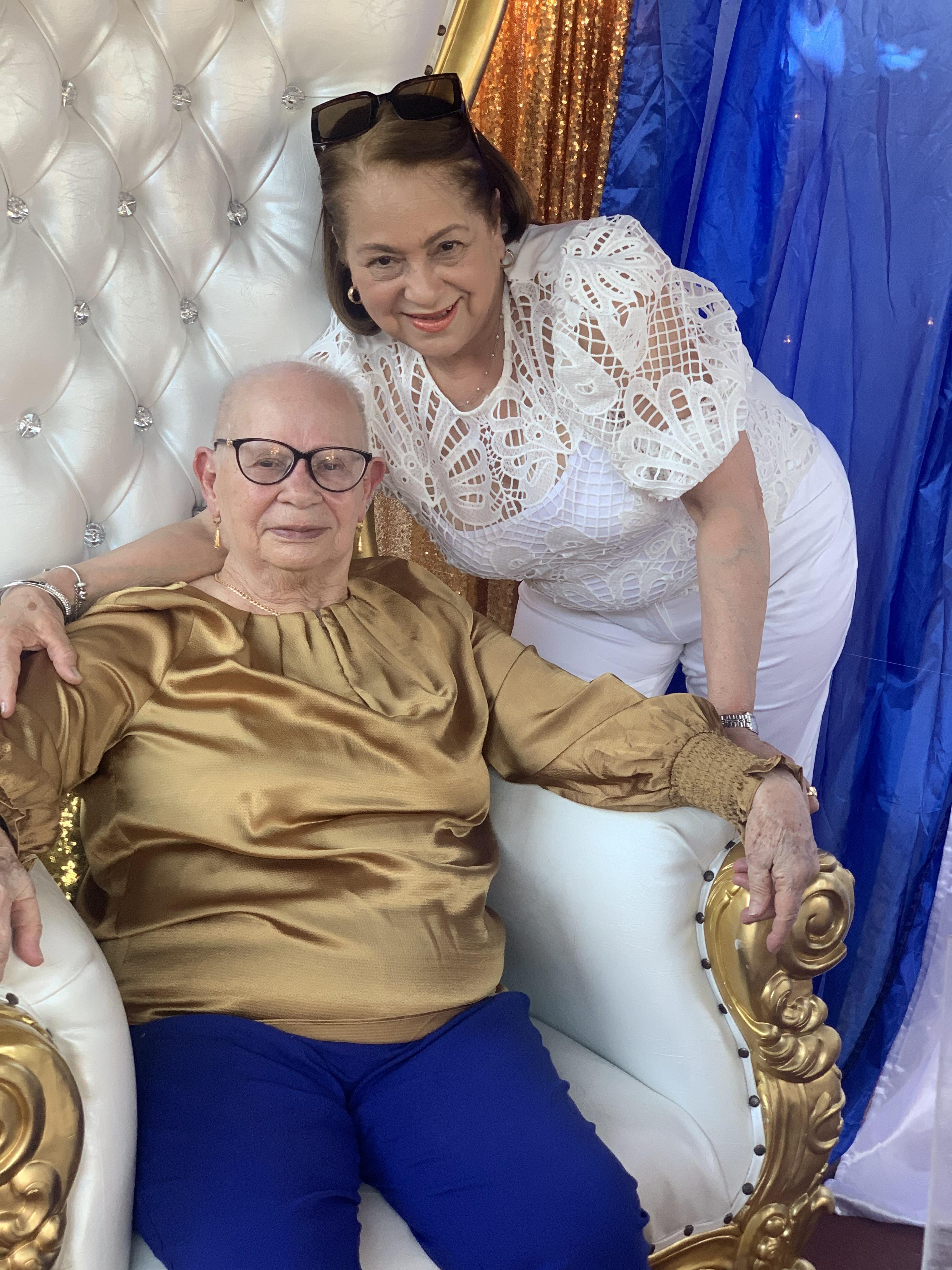 A woman leaning on an older woman in a chair