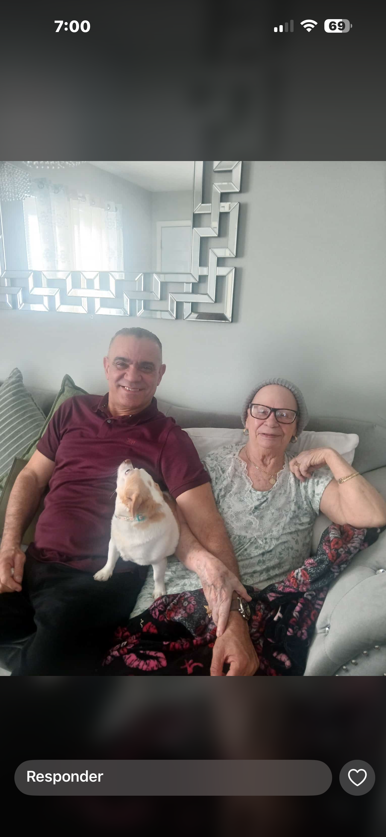 A man and woman sitting on a couch with a dog