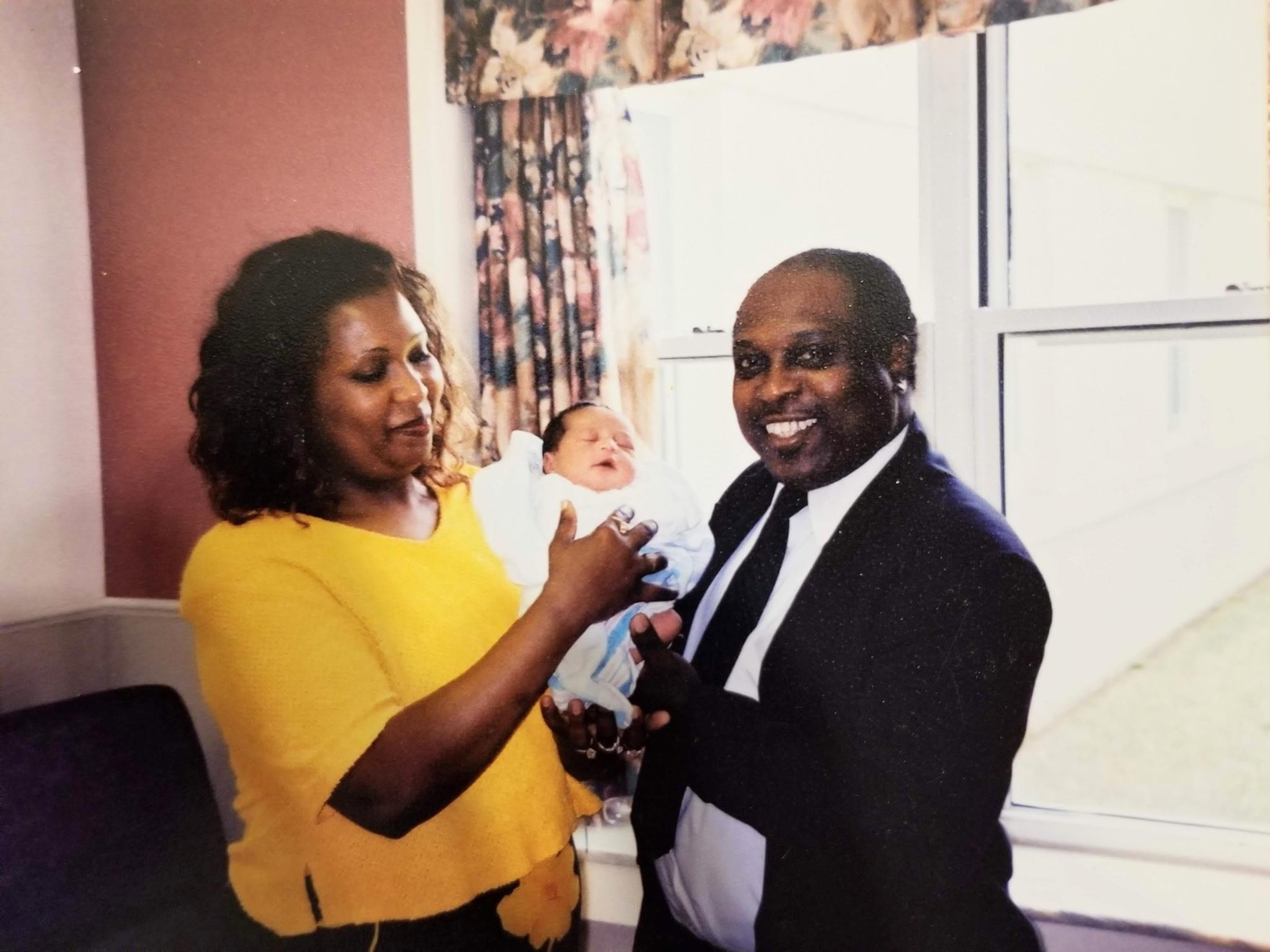 A man and woman holding a baby