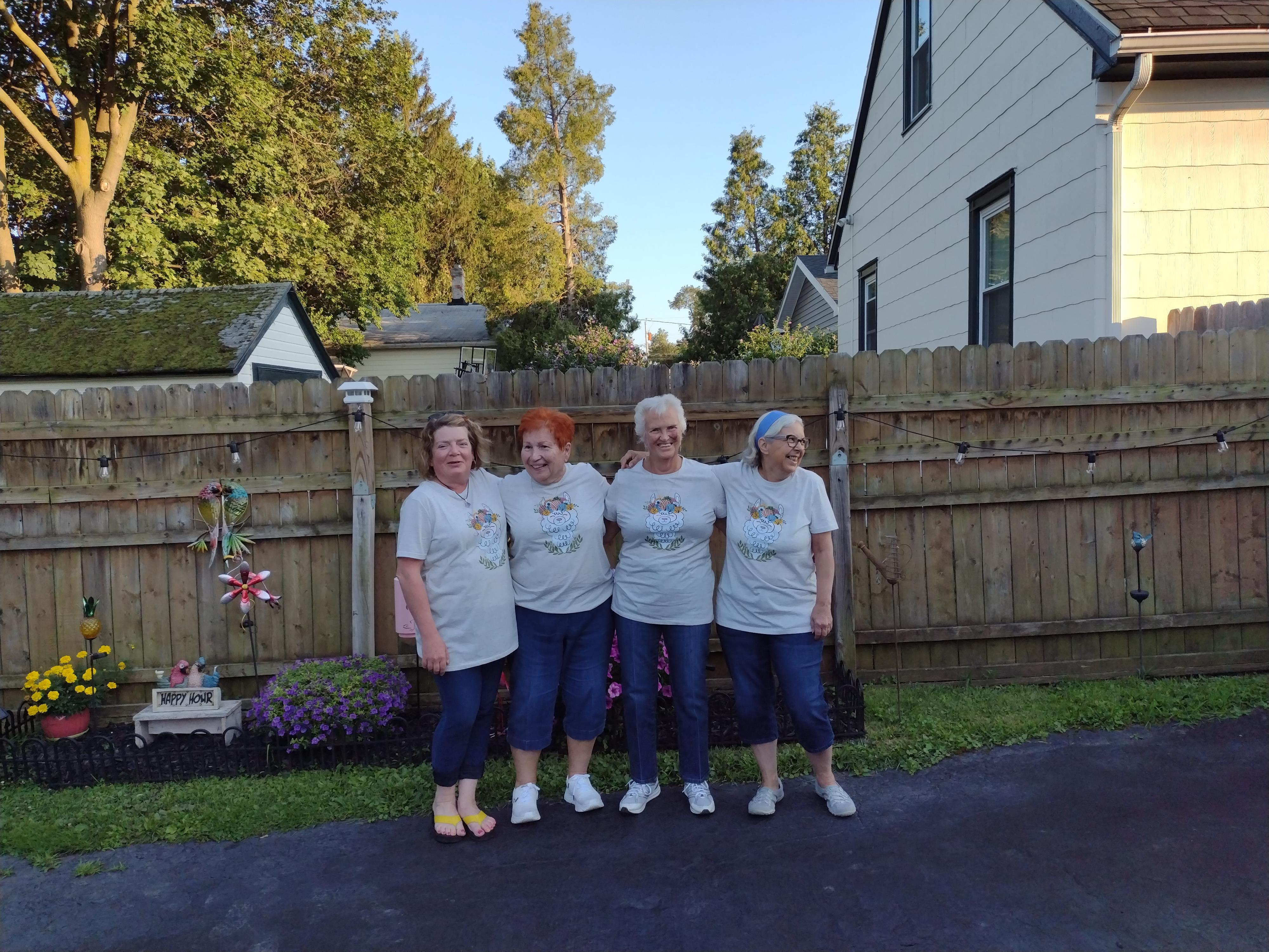 A group of women standing in front of a fence