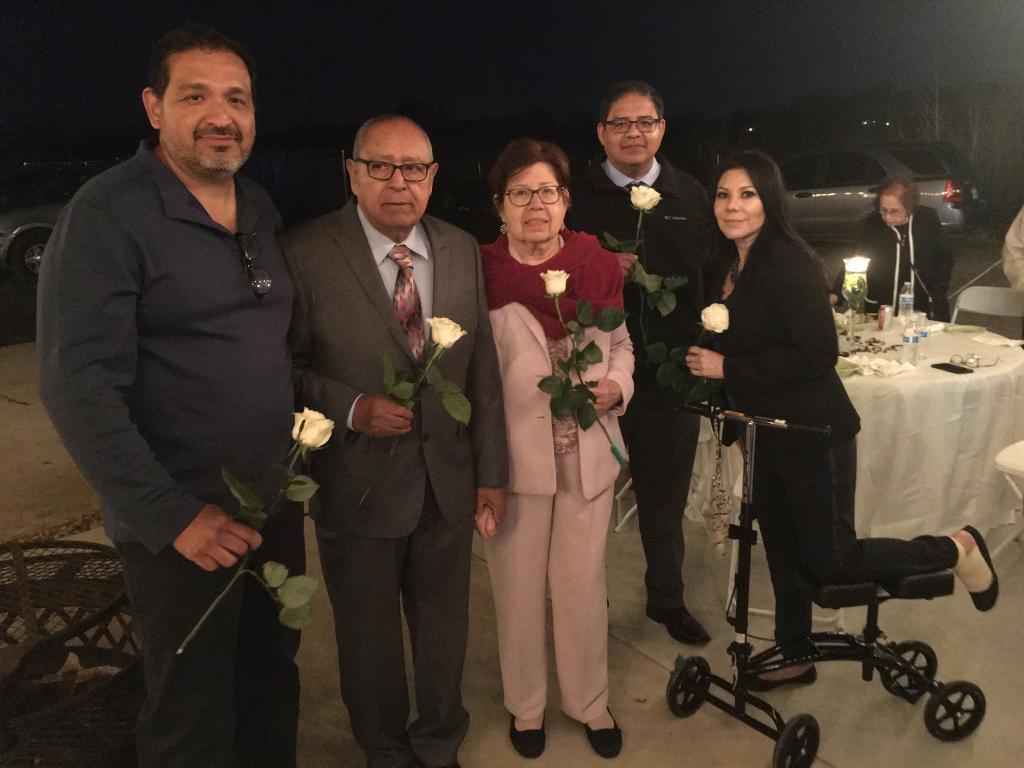 A group of people holding white roses