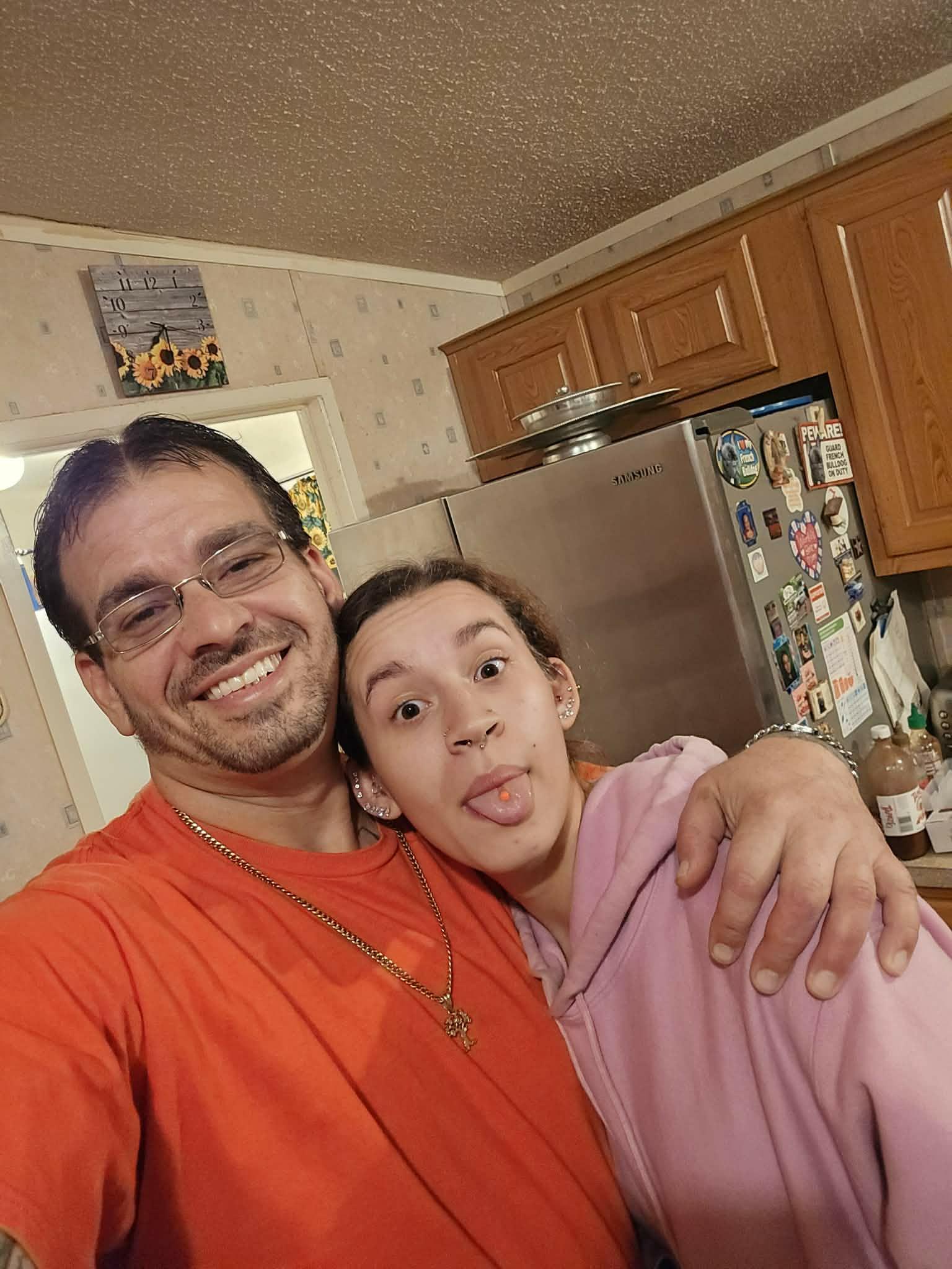 A man and woman taking a selfie in a kitchen