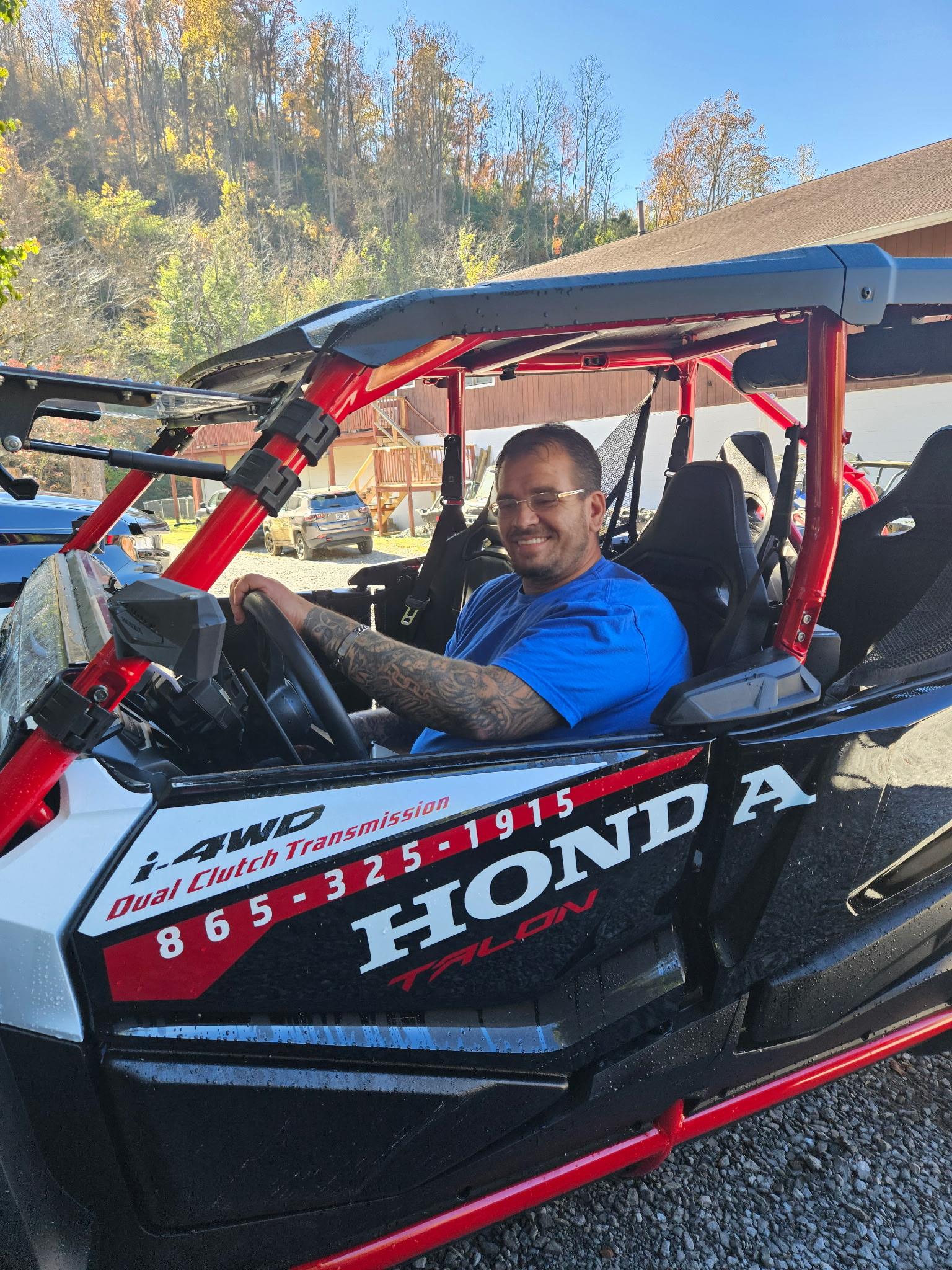 A man in a blue shirt sitting in a black and white vehicle