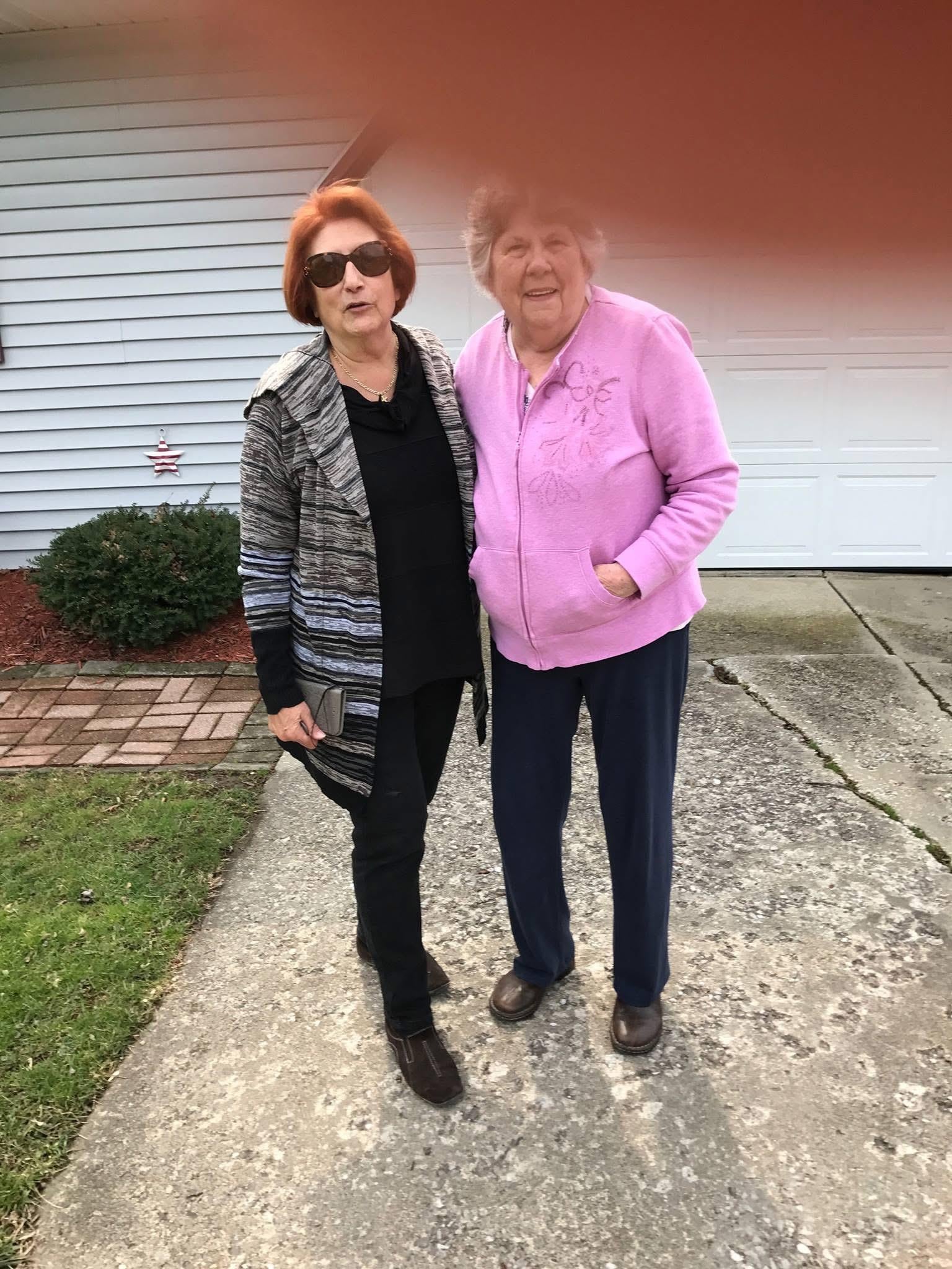 Two women standing on a sidewalk