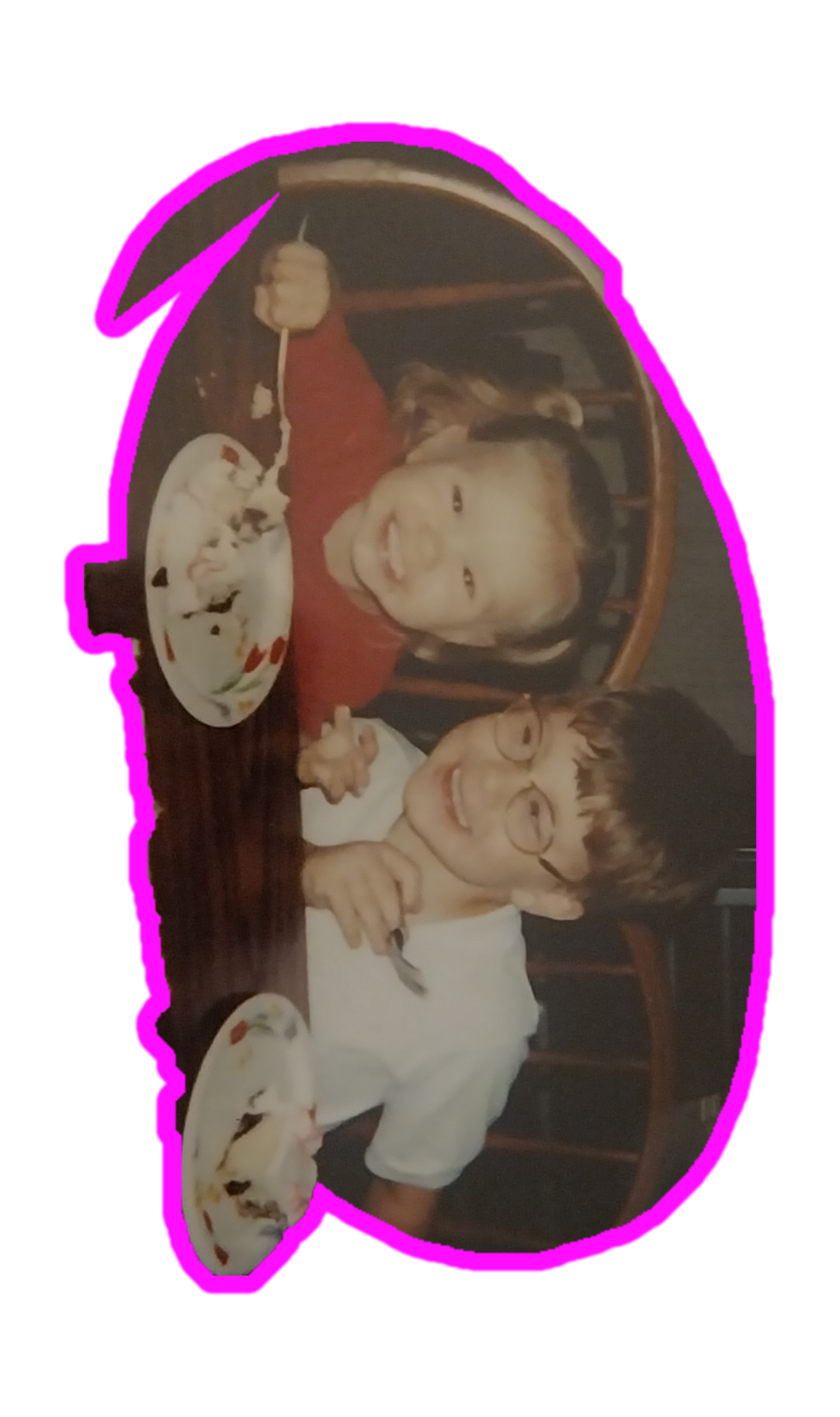 A boy and girl sitting at a table with plates of food