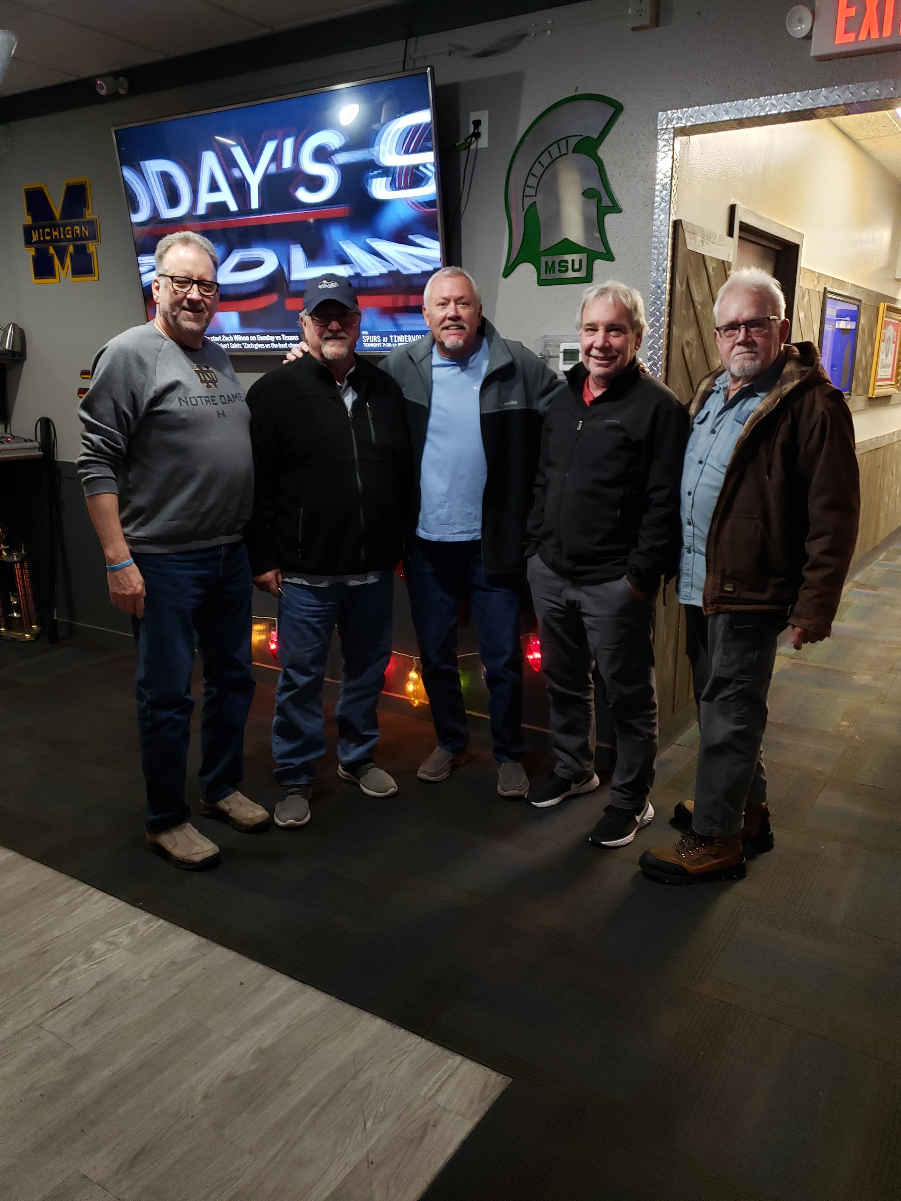 A group of men standing in front of a sign