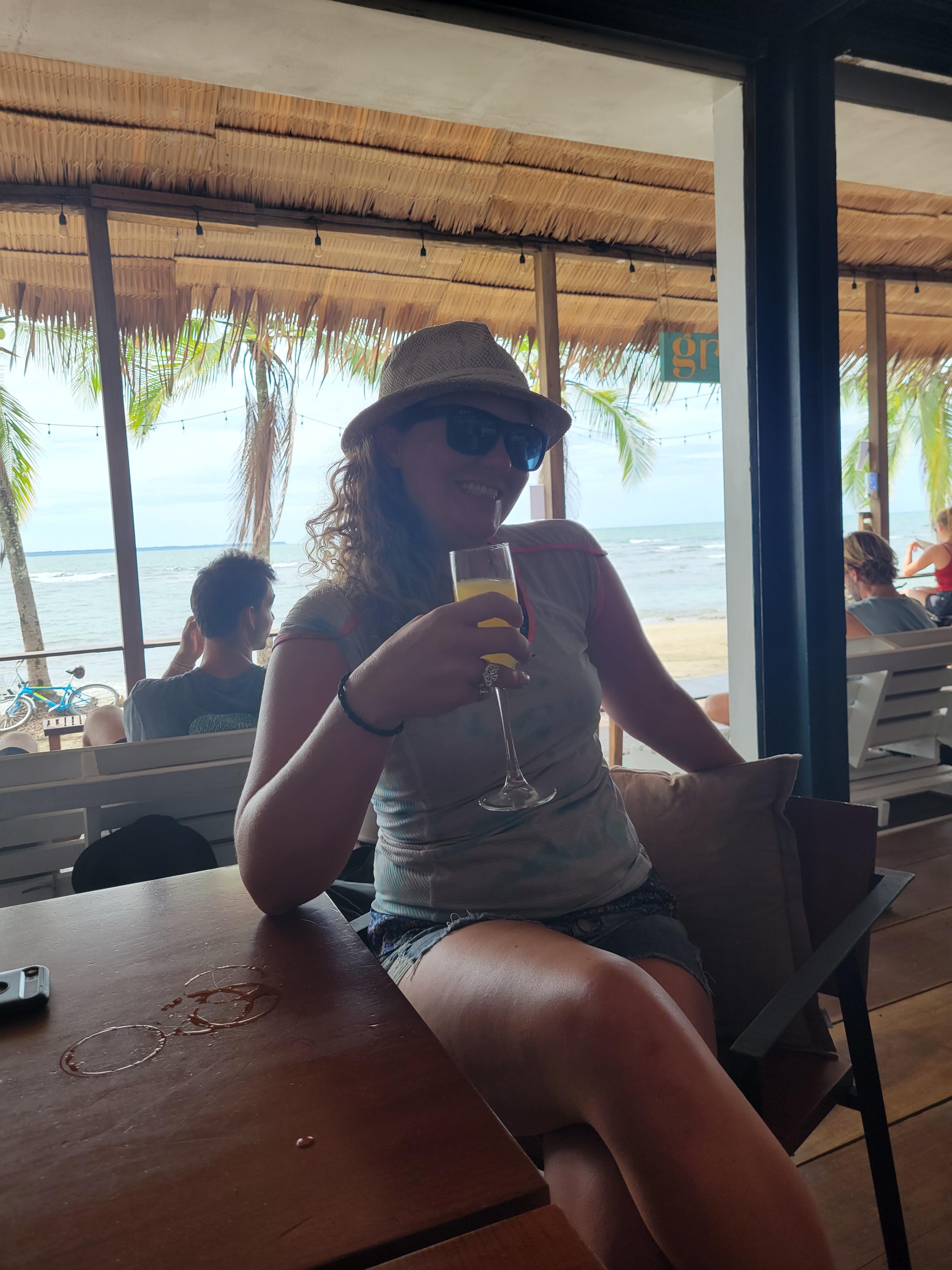 A woman sitting at a table with a glass of wine