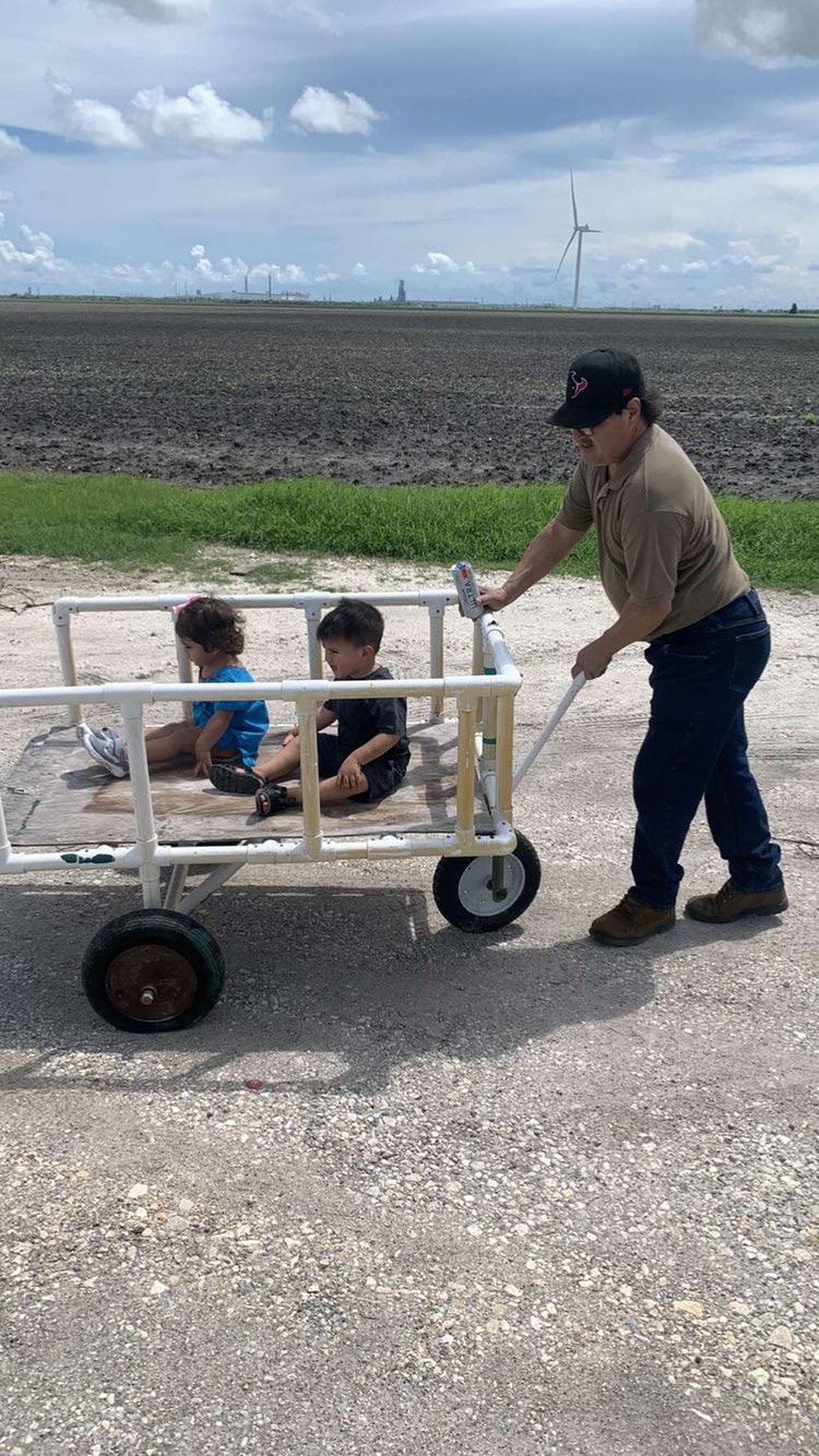 A man pushing a cart with two children
