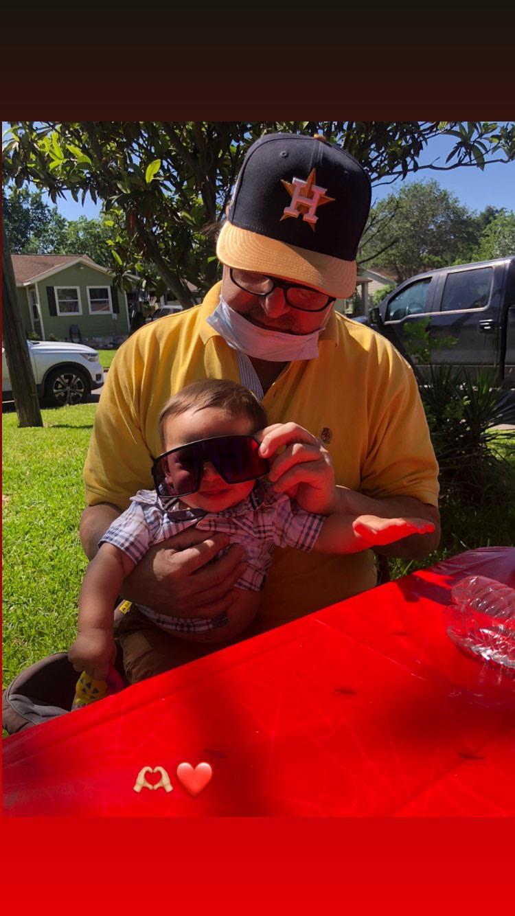 A man holding a baby wearing sunglasses