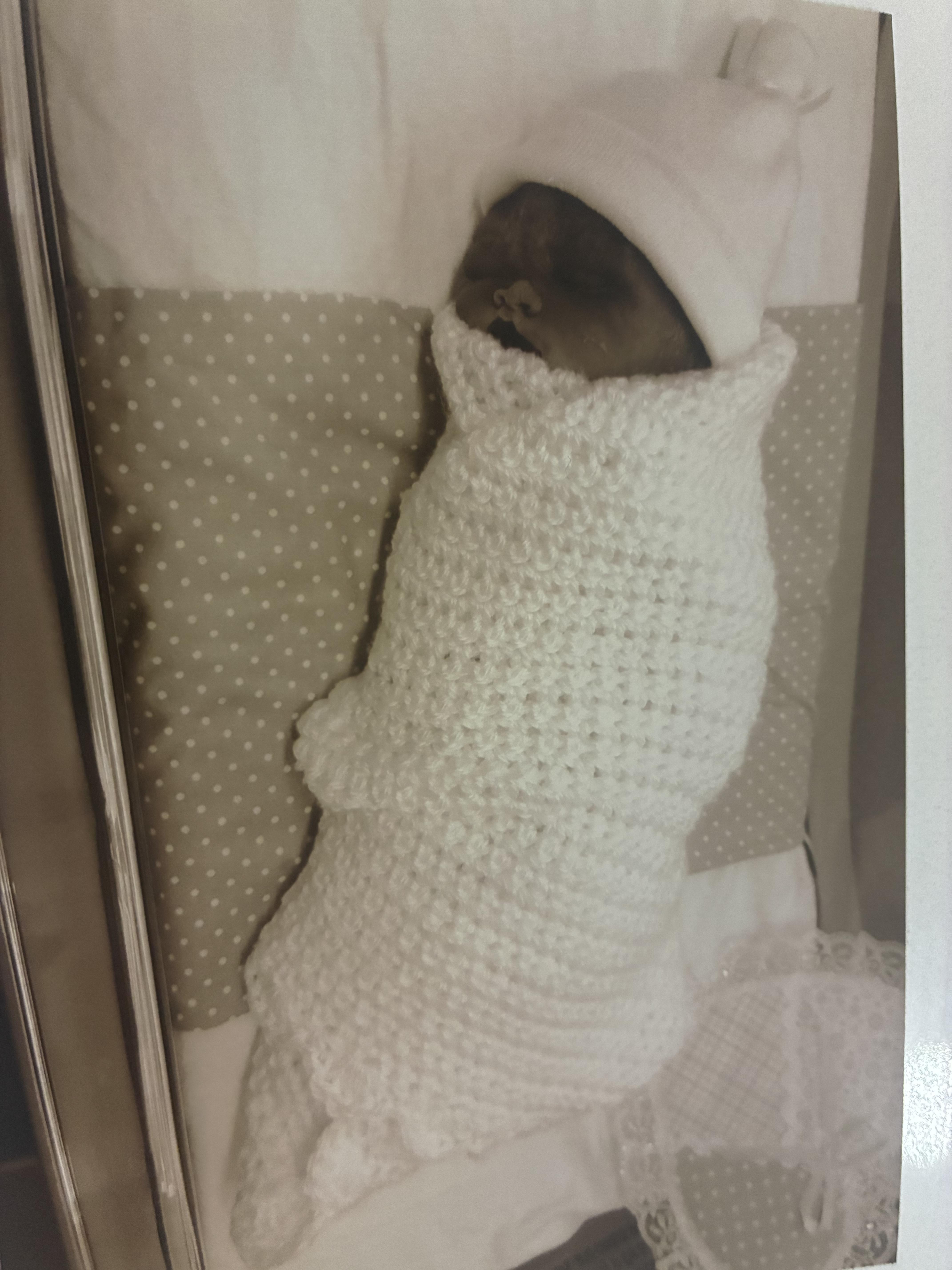 A baby wrapped in a white blanket