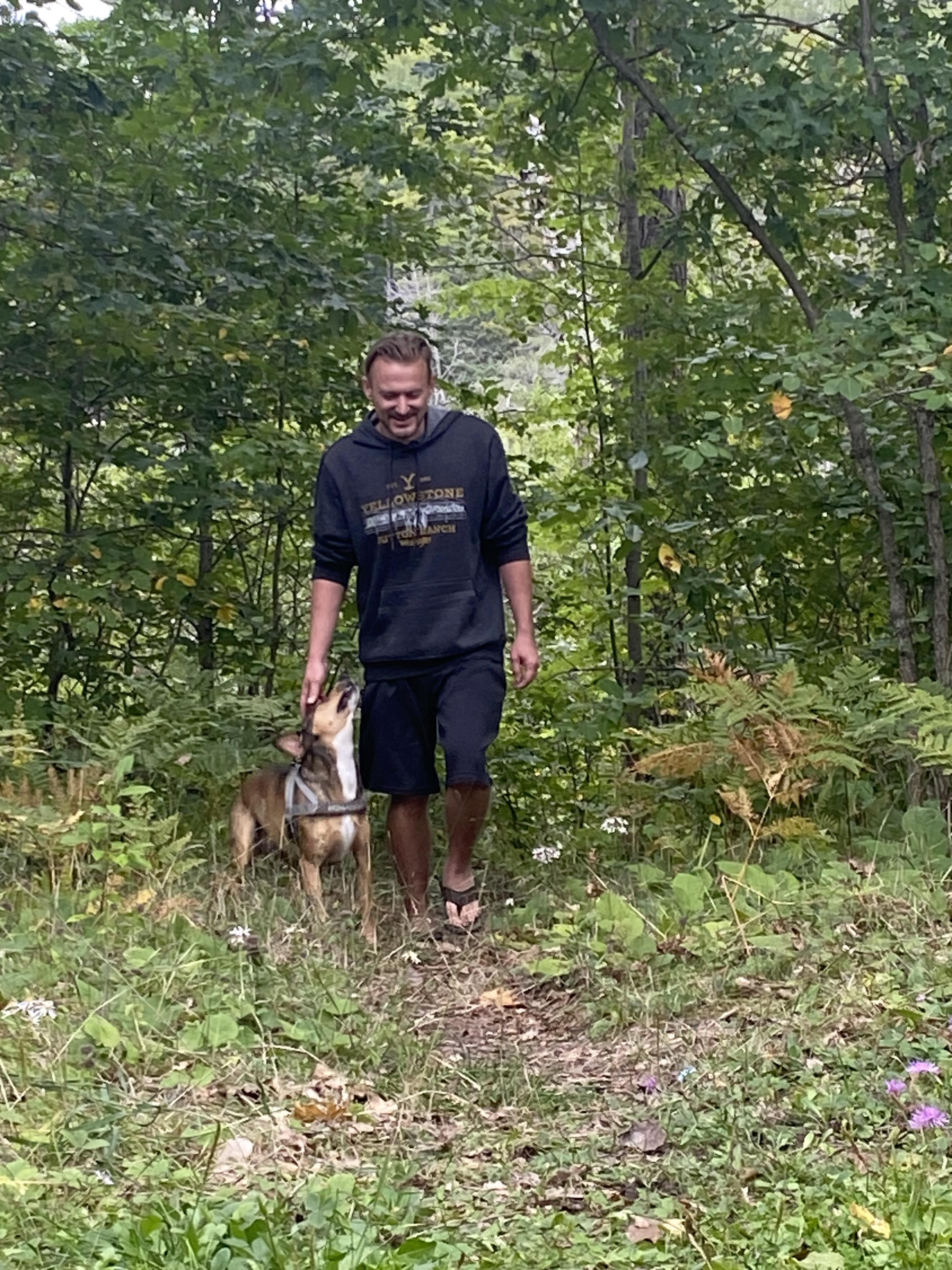 A man walking a dog in the woods