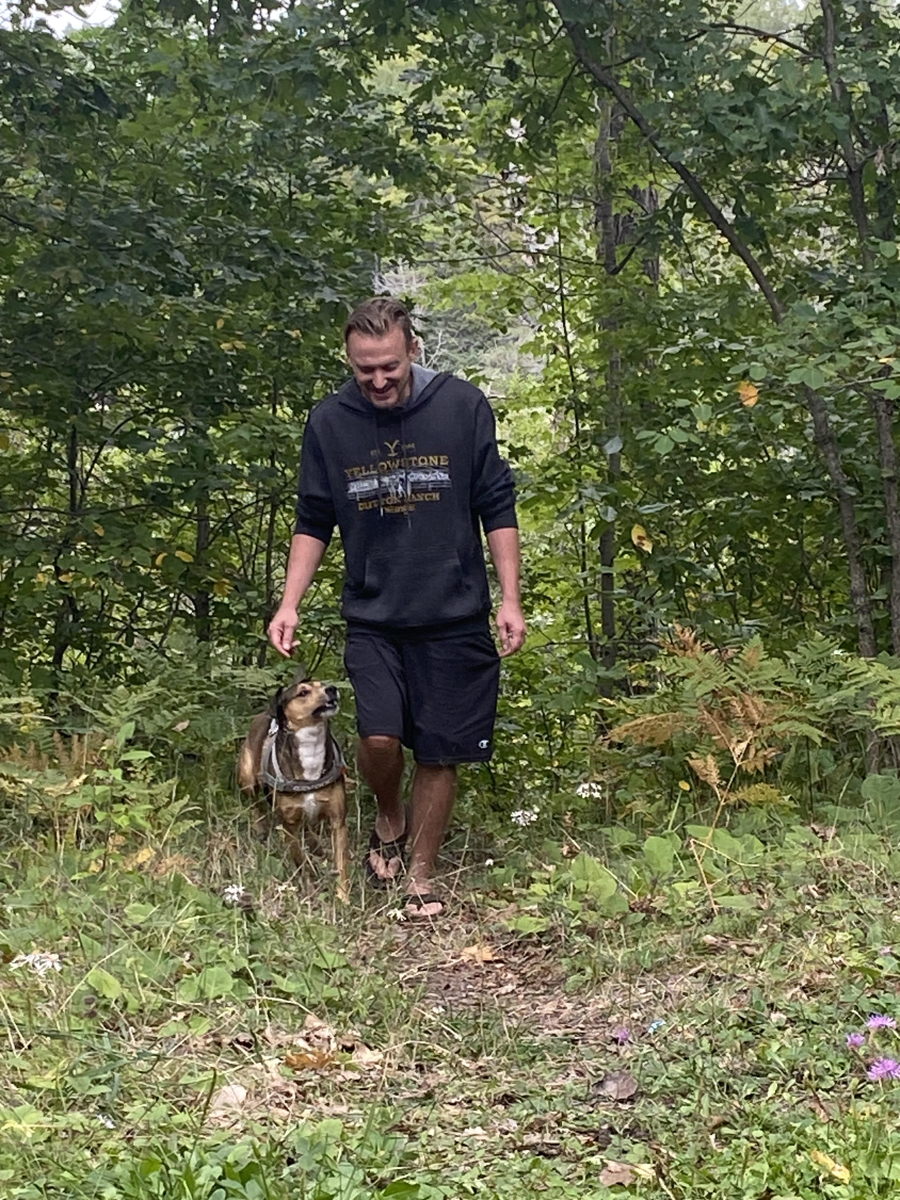 A man walking a dog in the woods