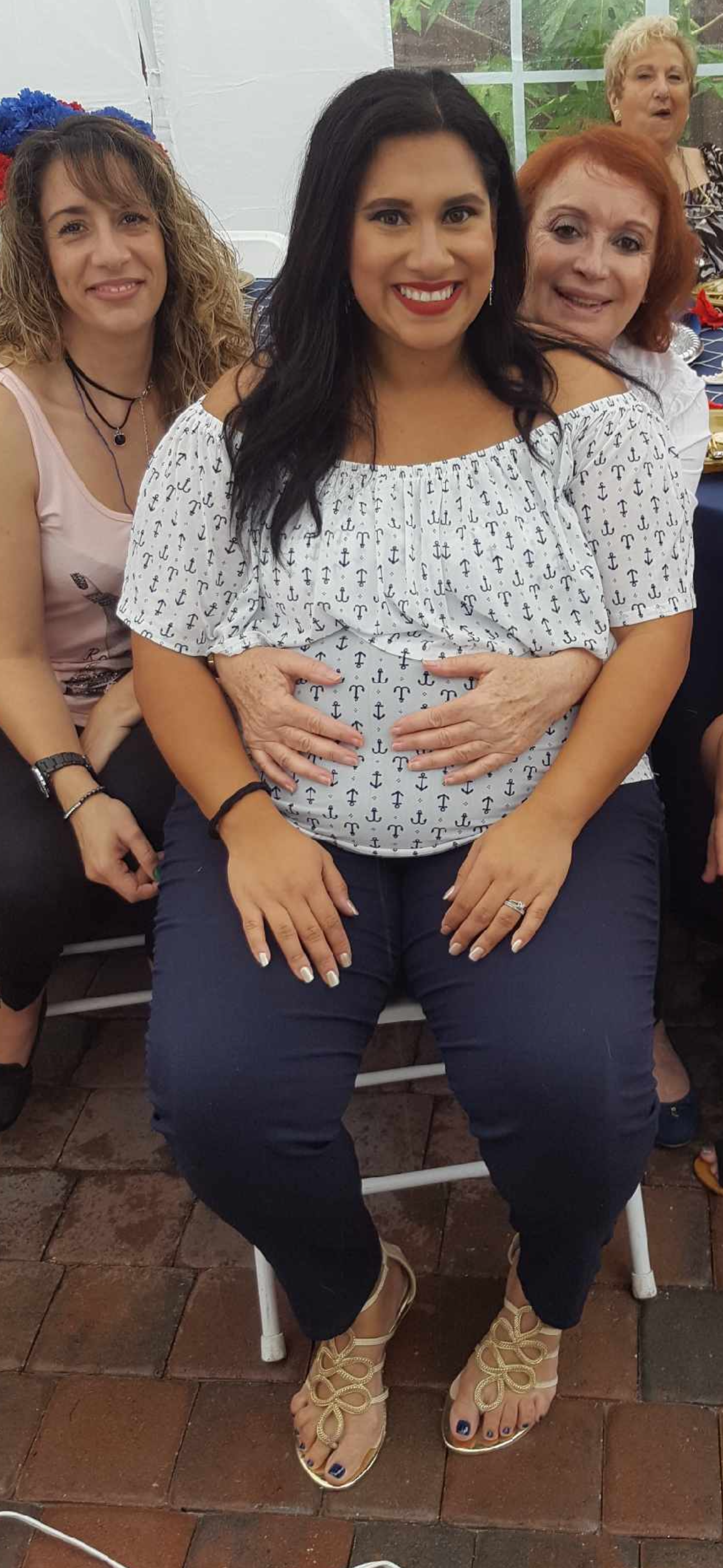 A woman sitting on a chair with her hands on her belly