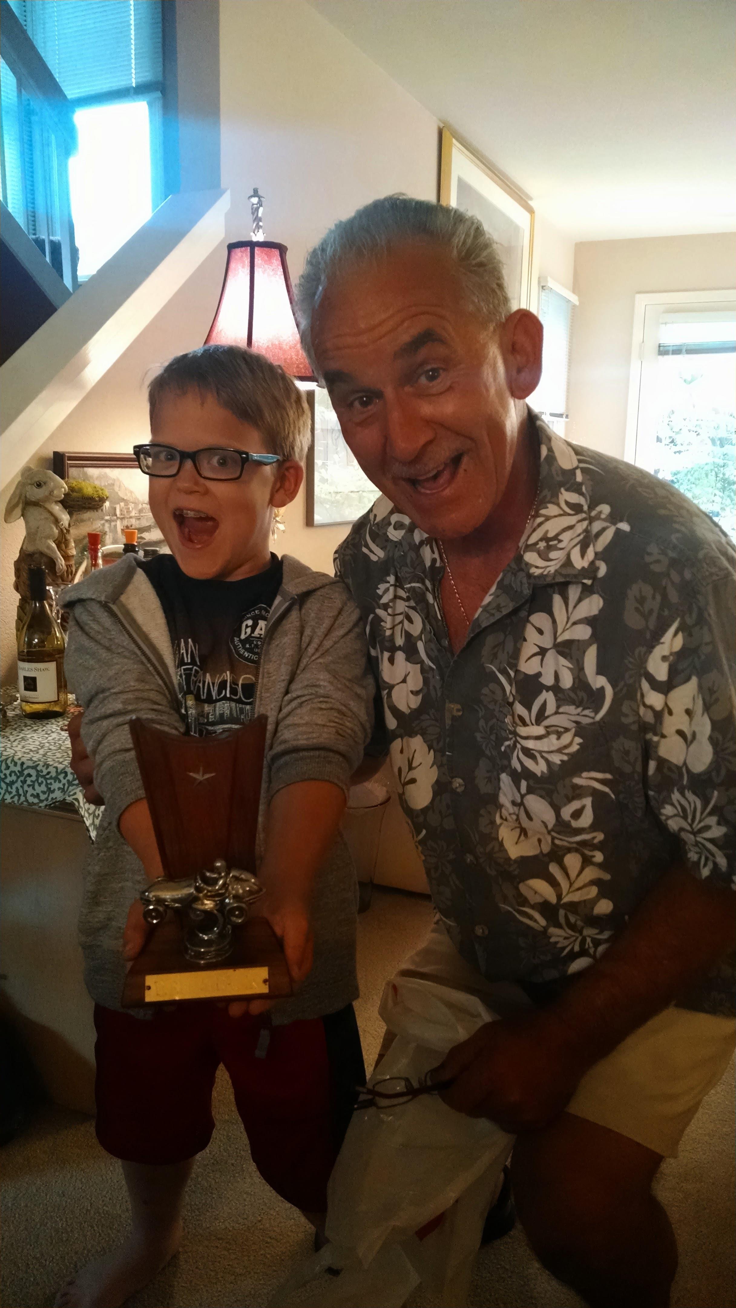 A man and boy holding a trophy