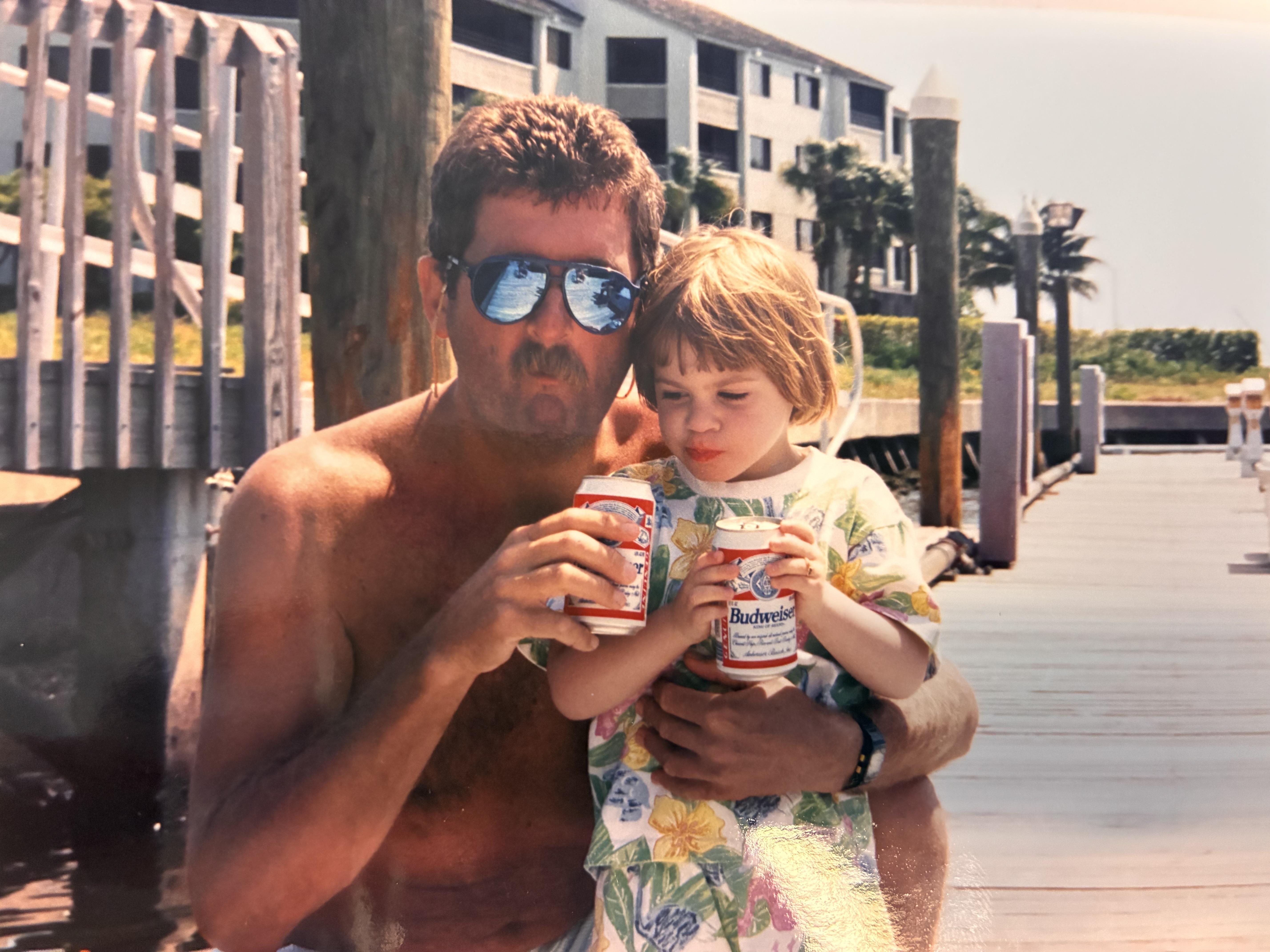 A man holding a child and a can